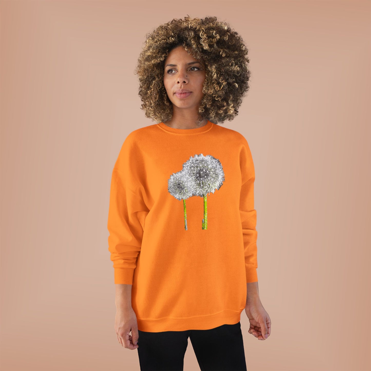 Woman in orange Tantrum Media Dandelion Unisex Sweatshirt with white dandelion print, peach background