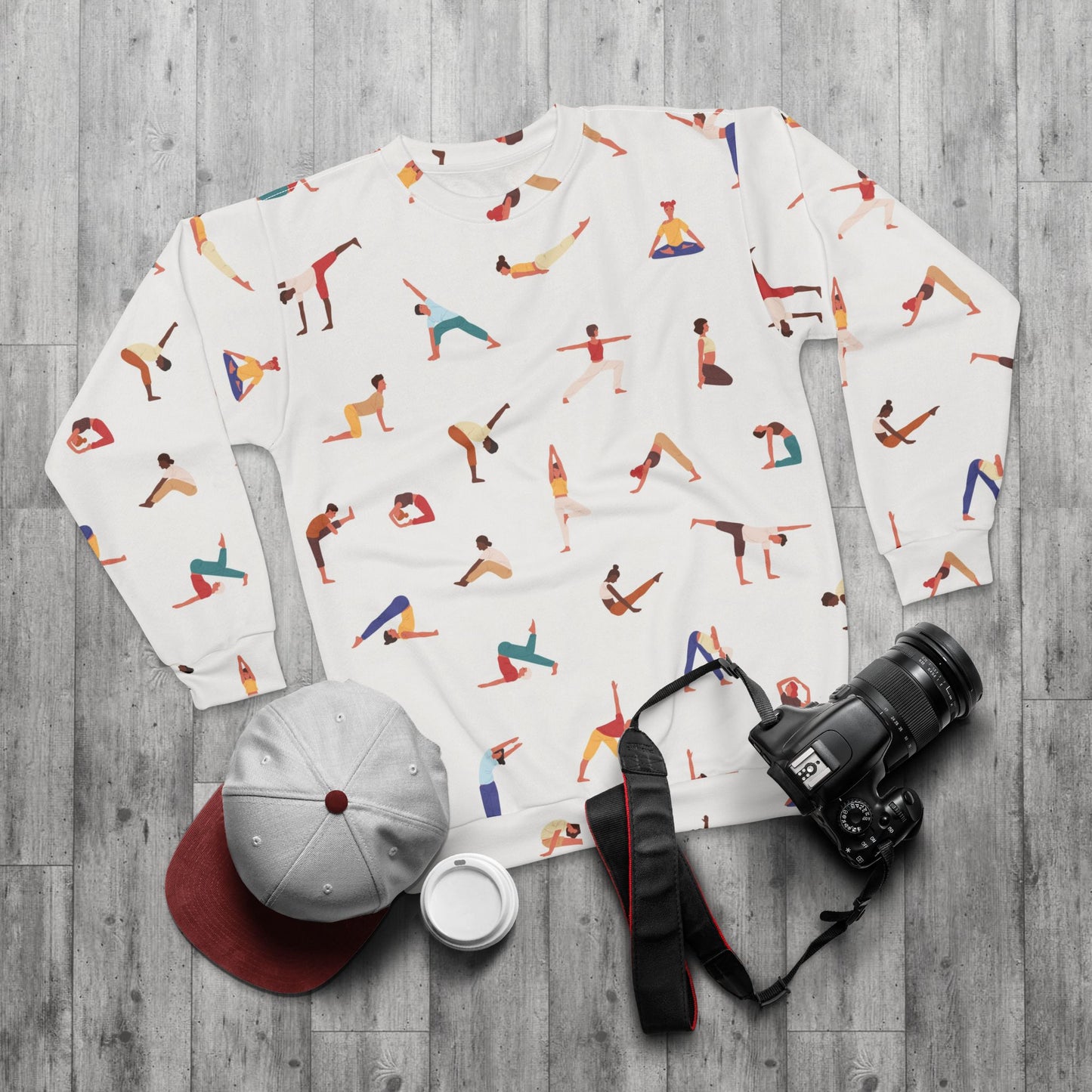 Flat lay of Yogini Sweatshirt with accessories including cap and camera