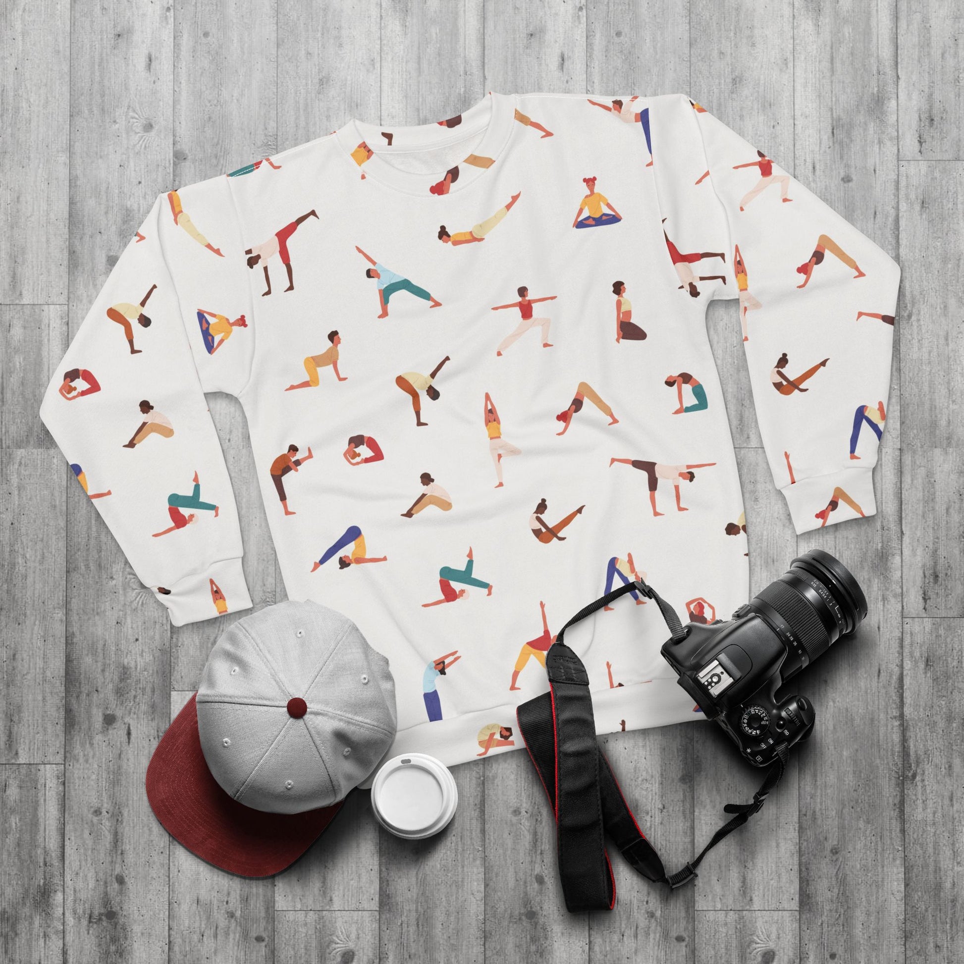 Flat lay of Yogini Sweatshirt with accessories including cap and camera