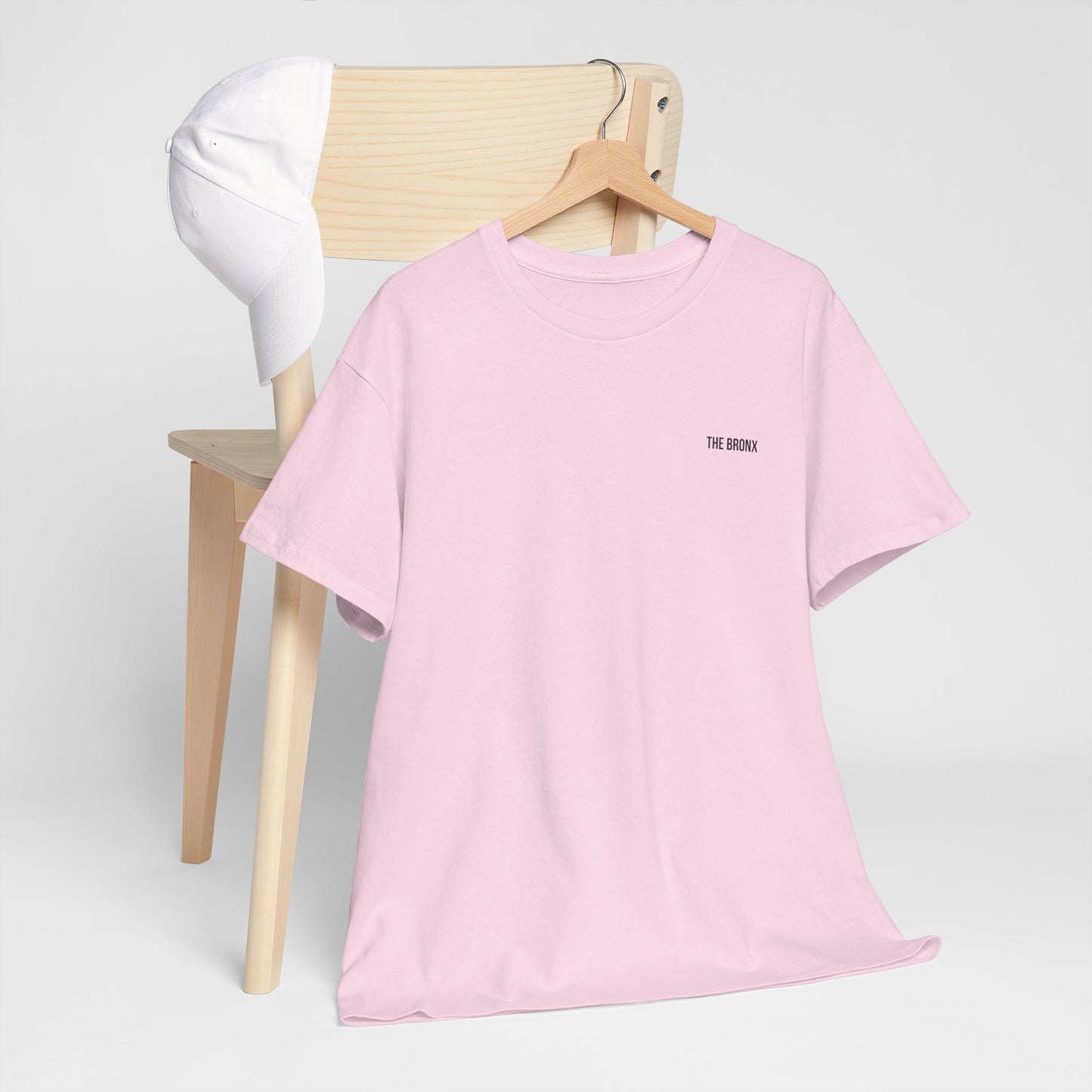 The Bronx T-Shirt in light pink displayed on hanger against chair