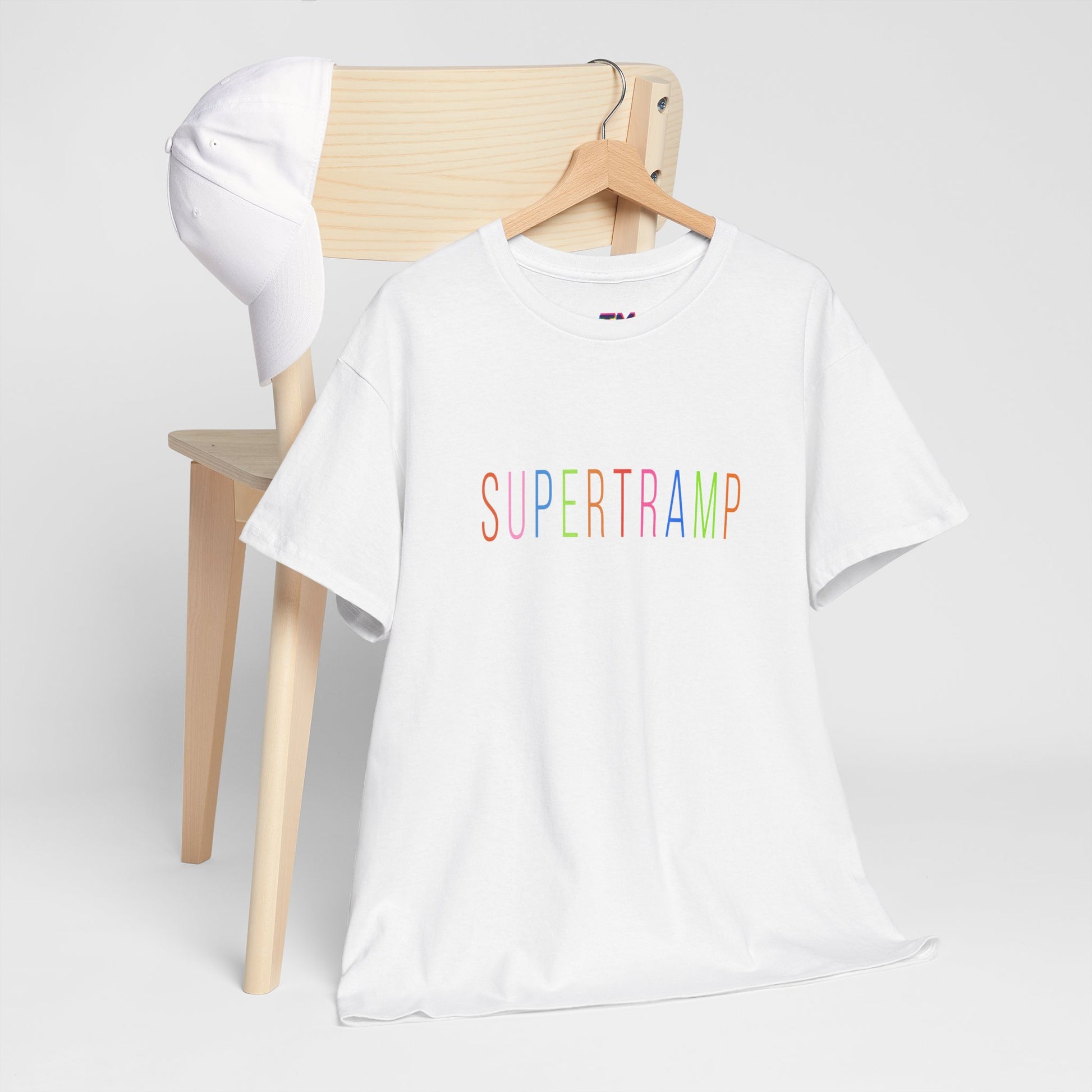 White Supertramp t-shirt on hanger and chair, showcasing multicolor logo.