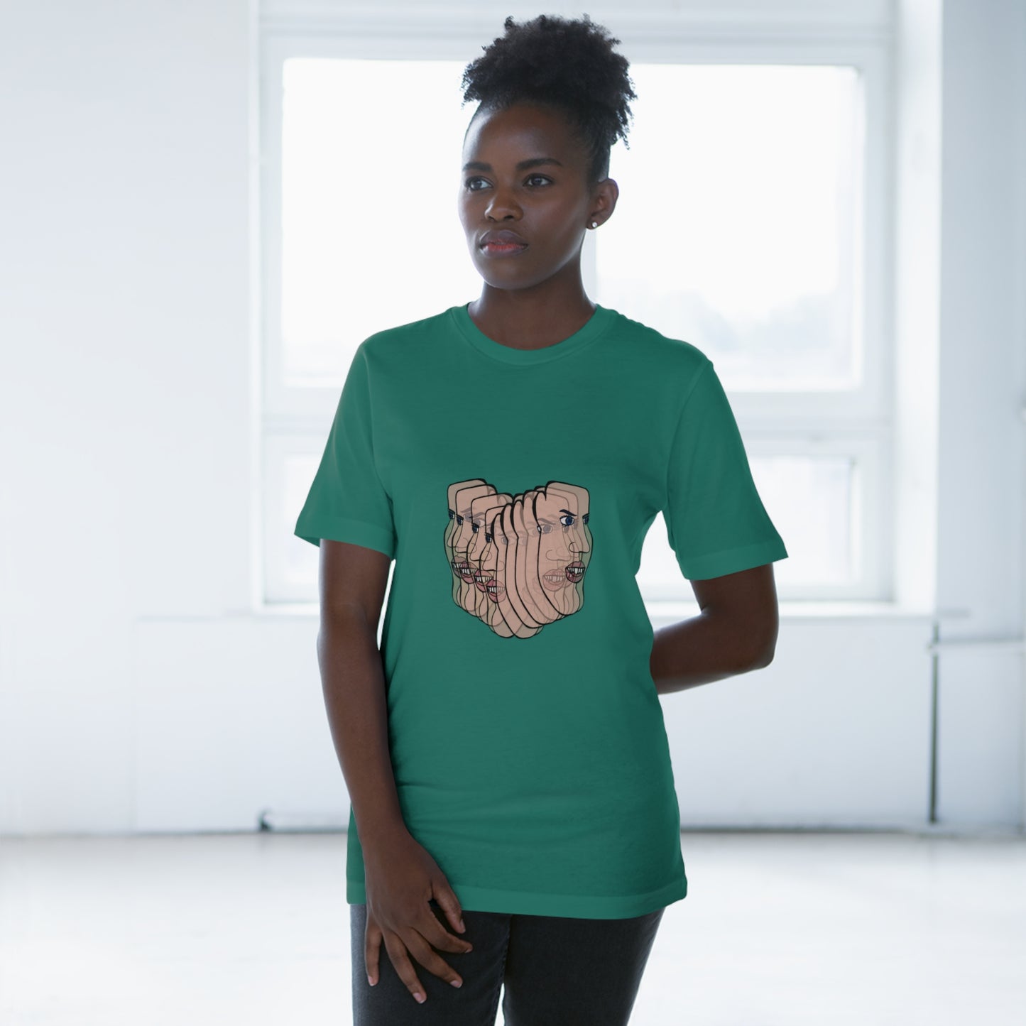 Person wearing forest green Charlie tee, standing by window
