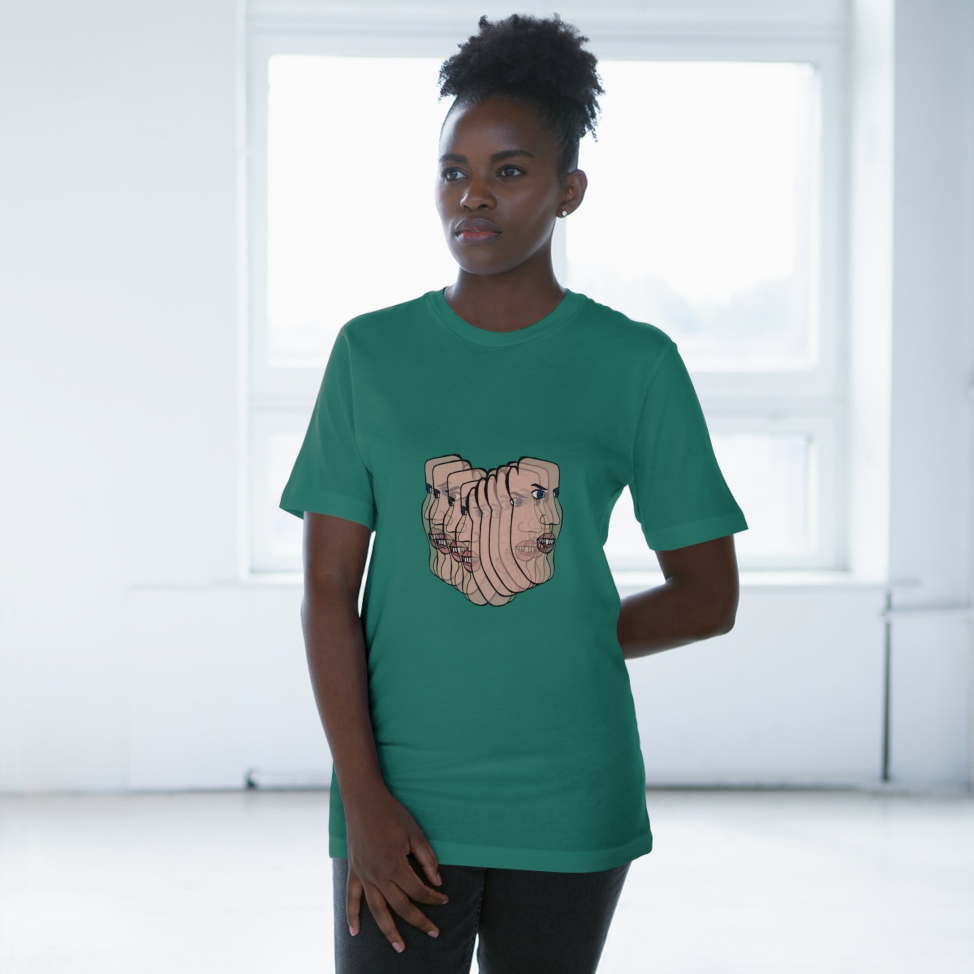 Person wearing forest green Charlie tee, standing by window