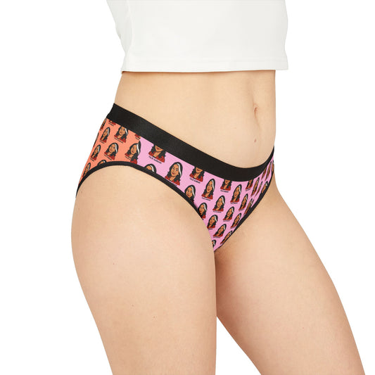 Model wearing Tulsi Gabbard underwear with pink-to-orange gradient and all-over face print, black waistband, side front view