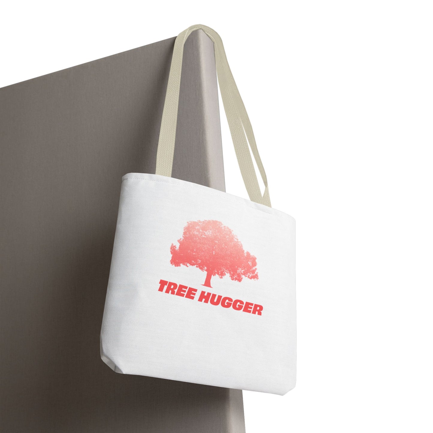 Tree Hugger Tote Bag hanging on chair with red tree graphic