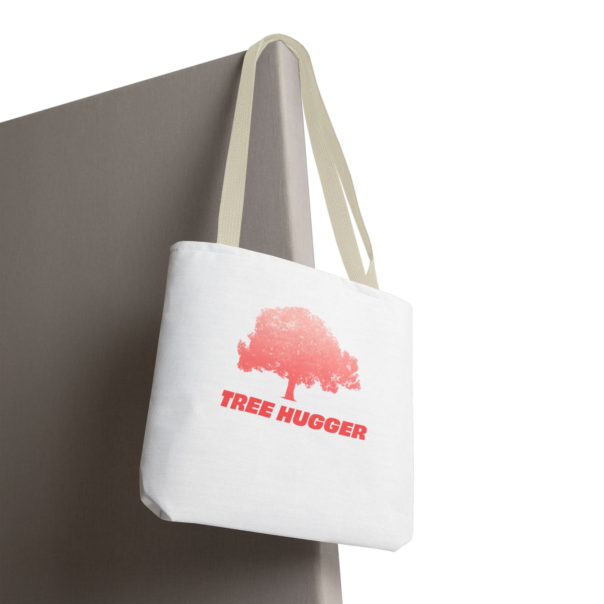 Tree Hugger Tote Bag hanging on chair with red tree graphic