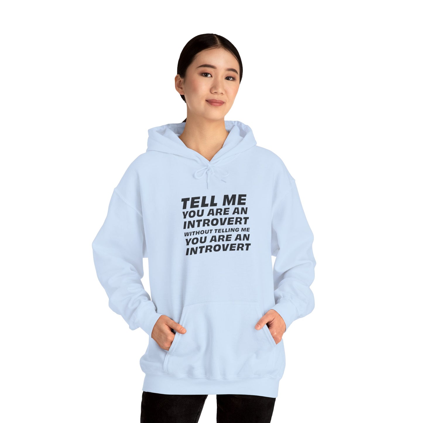 Front view of woman wearing light blue introvert hoodie with hands in pocket