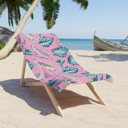 Tropical Leaves Towel draped over a wooden lounge chair on a sandy beach with palm trees