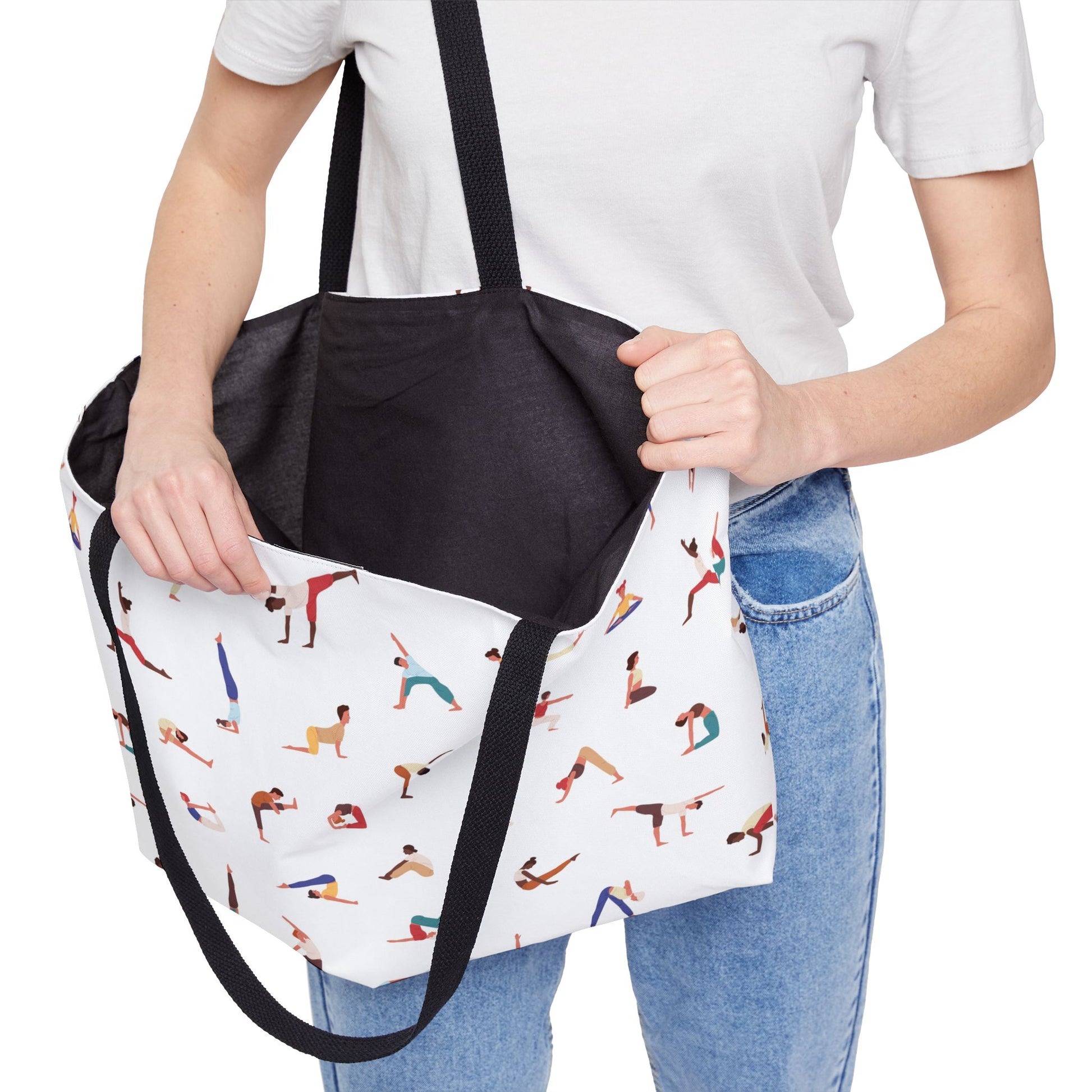 Person holding a tote bag with yoga poses design and black interior pocket.