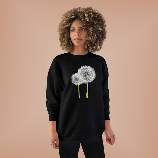Woman in black Tantrum Media Dandelion Unisex Sweatshirt with white dandelion print, peach background