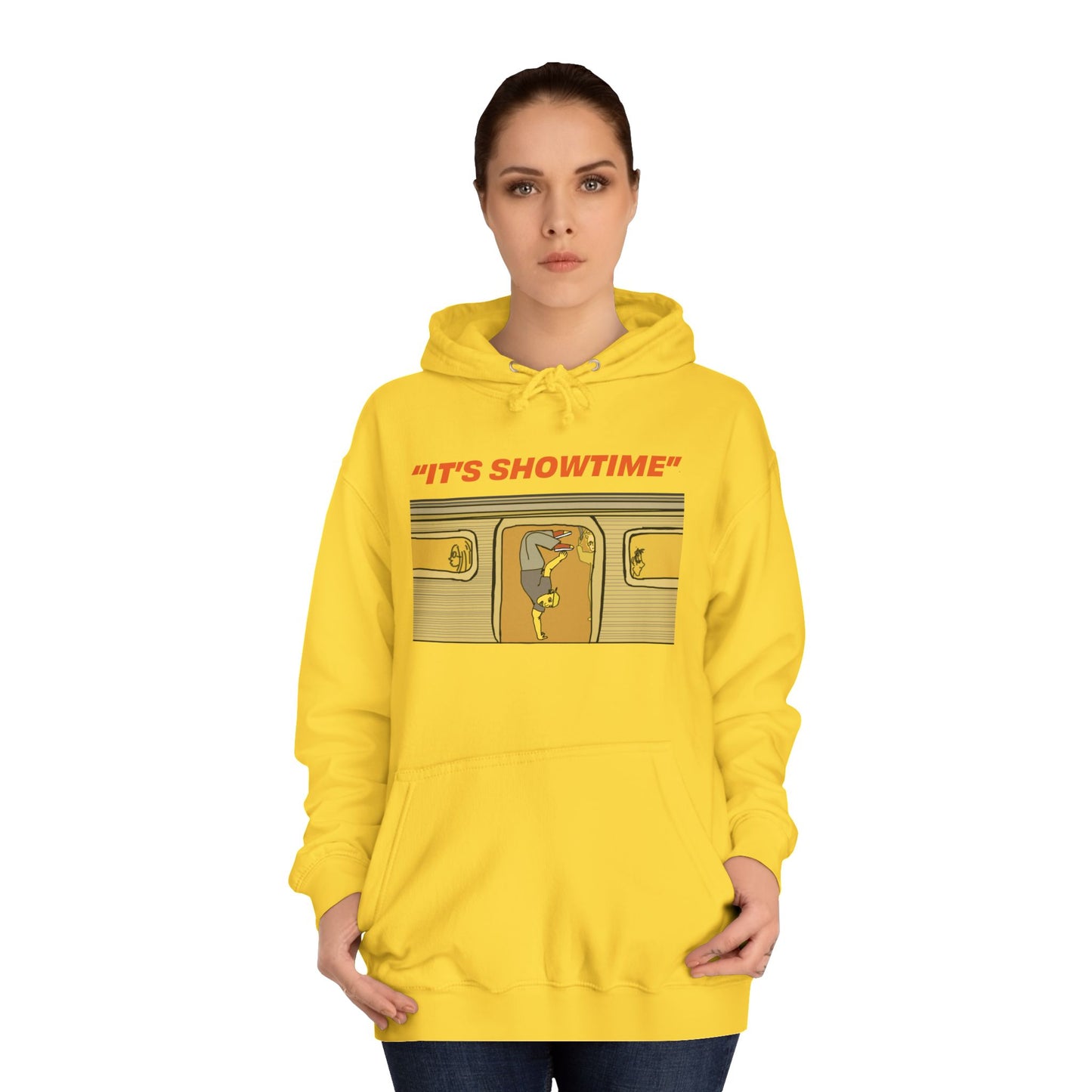 Female model wearing yellow It’s Showtime Hoodie with subway performer artwork on front.