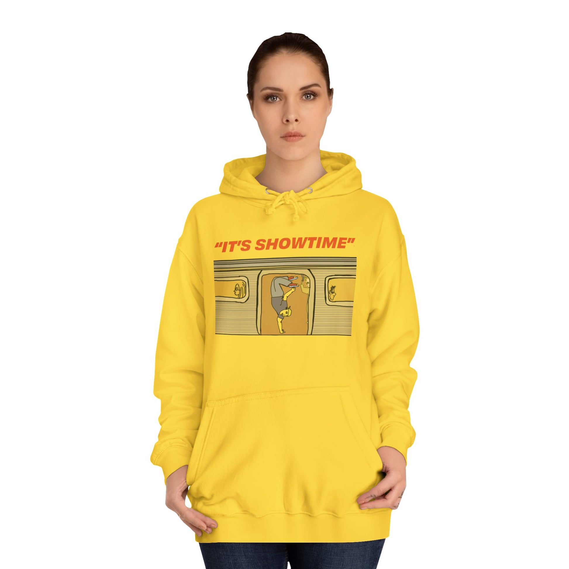 Female model wearing yellow It’s Showtime Hoodie with subway performer artwork on front.