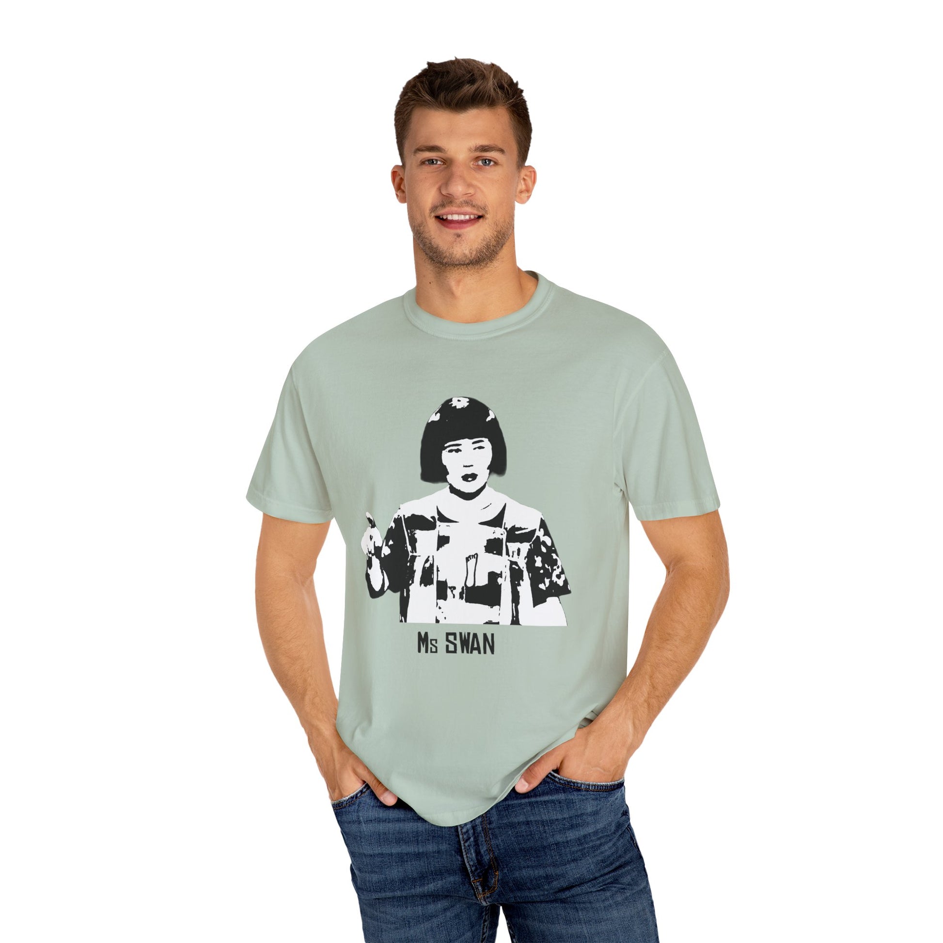 Man modeling light sage green Ms. Swan MadTV graphic T-shirt, smiling with hands in pockets.