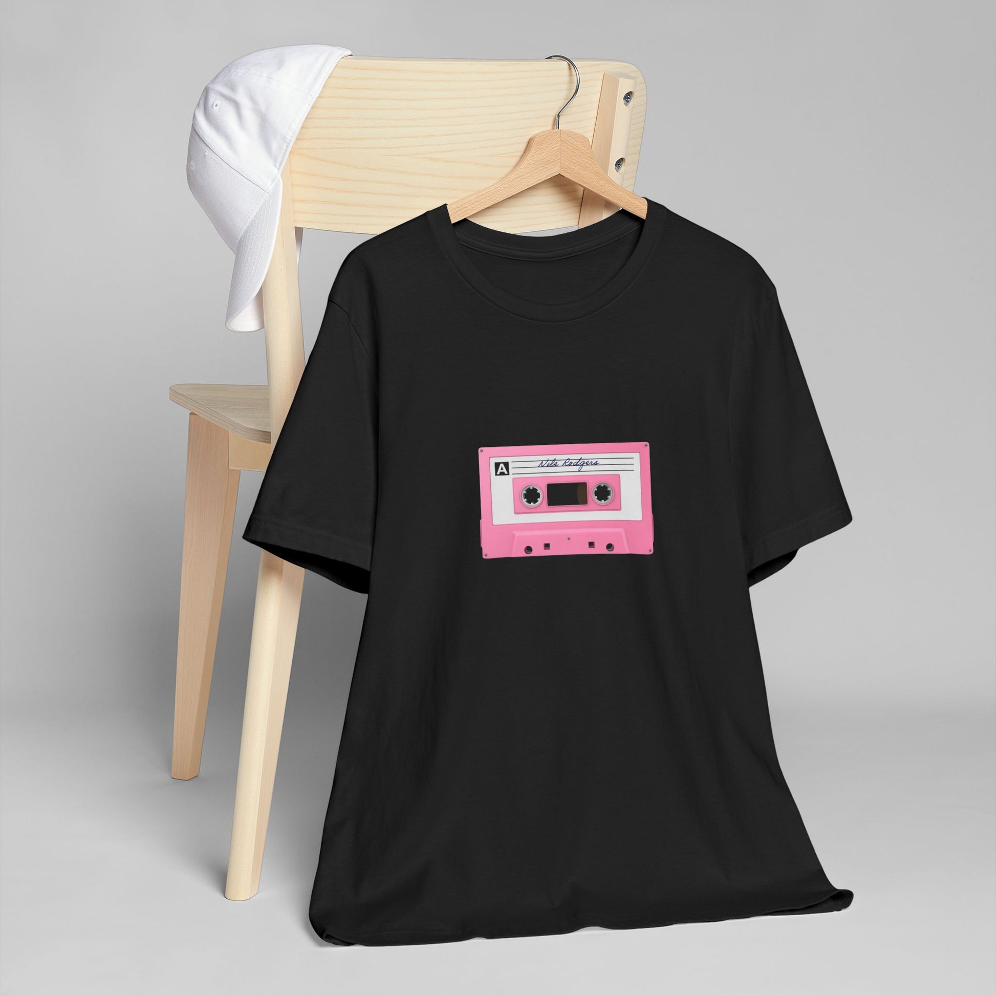 Black t-shirt with a pink cassette tape graphic on a gray background