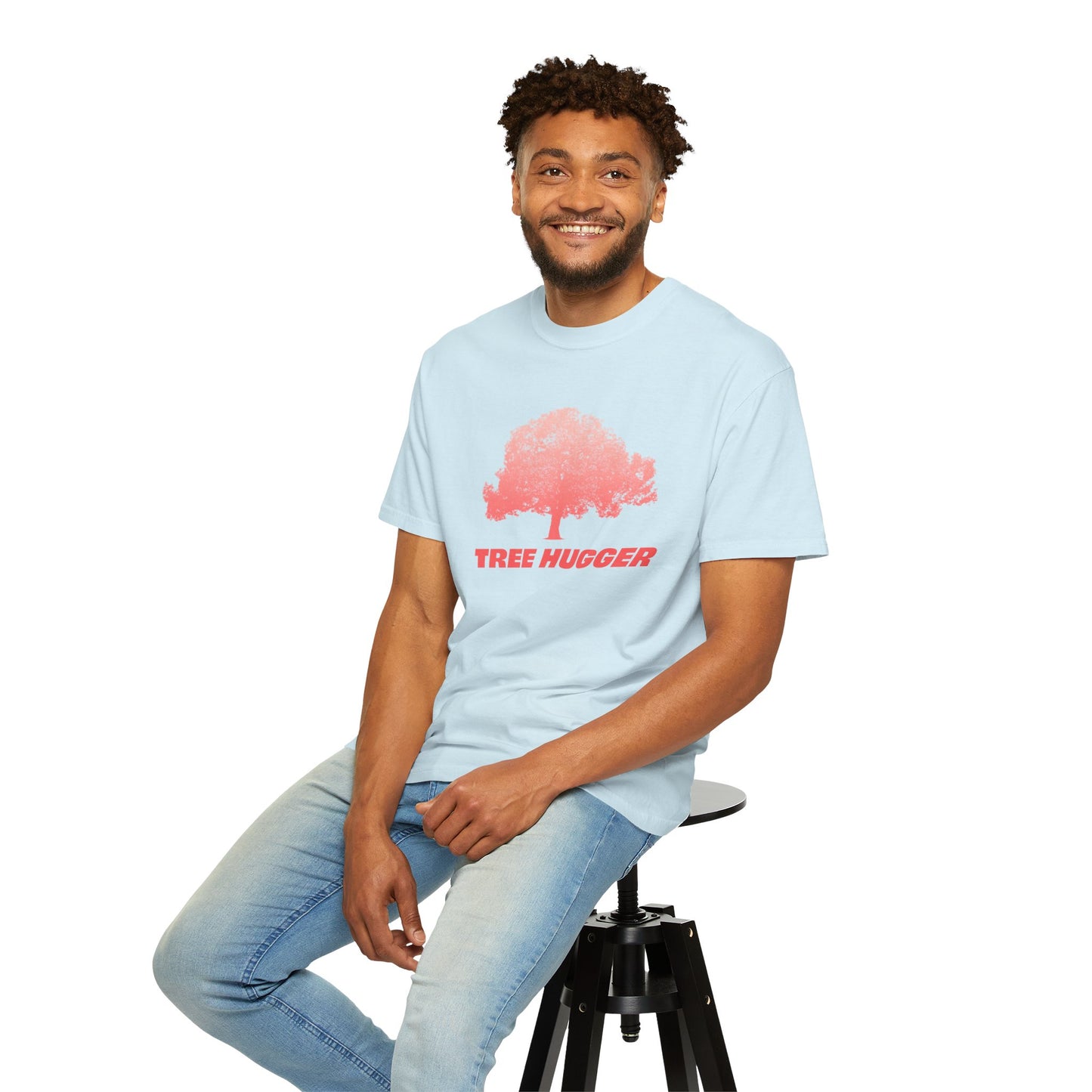 Man sitting wearing light blue Tree Hugger T-shirt with red tree graphic