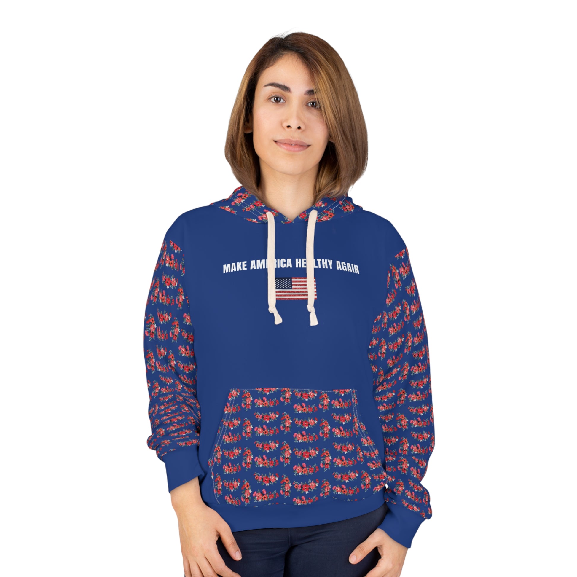 A person wearing a royal blue unisex hoodie that reads "Make America Healthy Again" with an American flag graphic, featuring red floral patterned sleeves and front pocket, standing against a white background.
