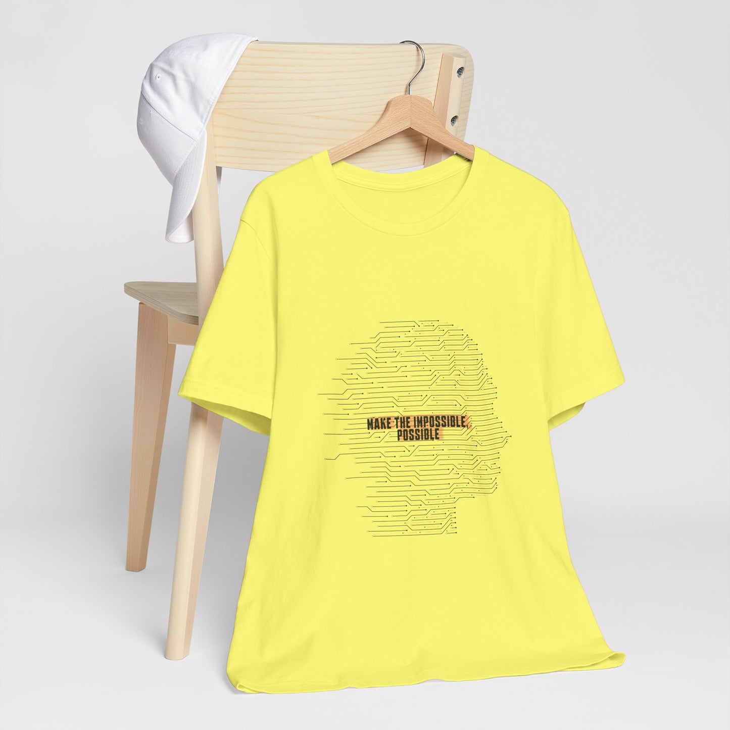 Yellow t-shirt with text design on a wooden chair against a white background