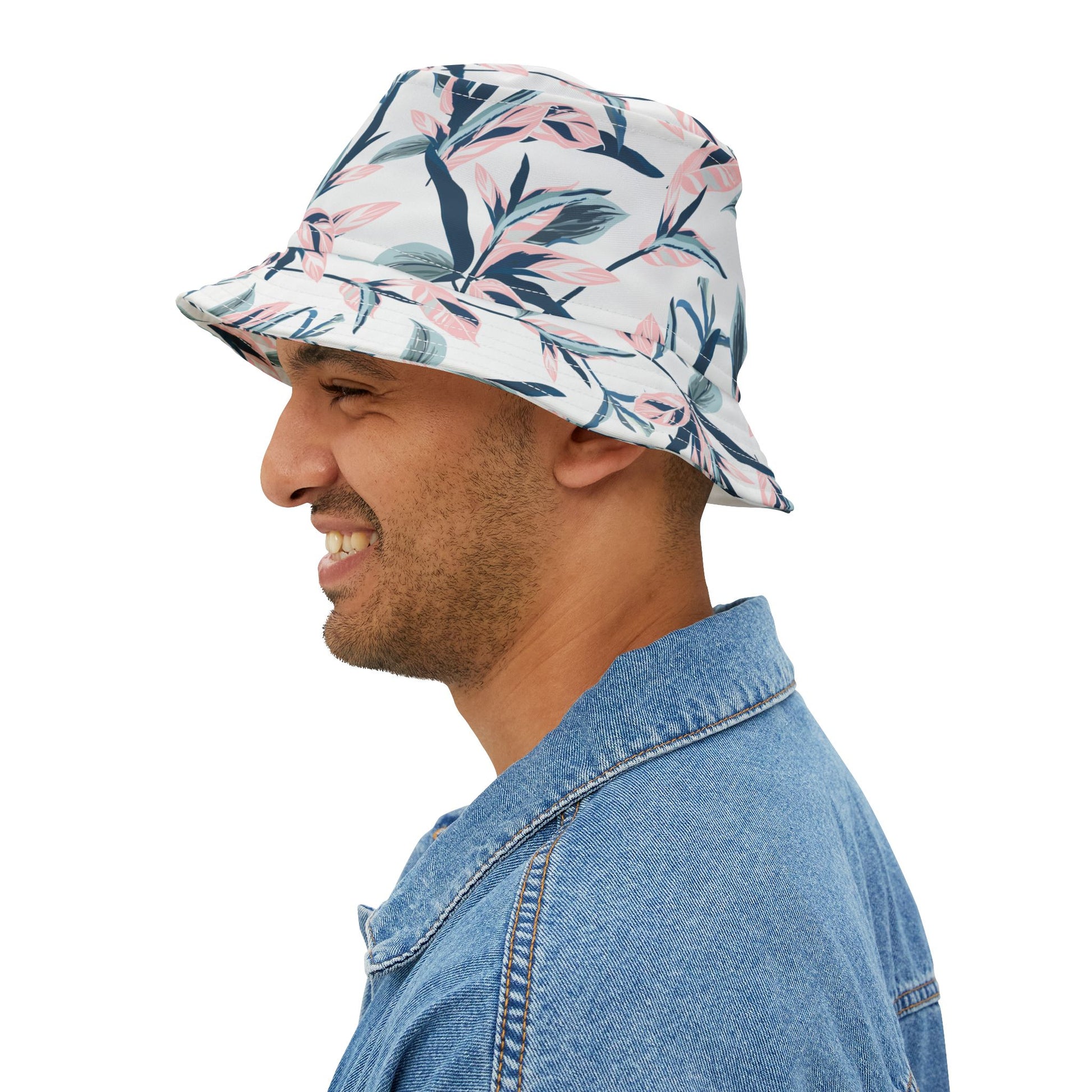 Man wearing floral bucket hat with watercolor blossom print, side view smiling.