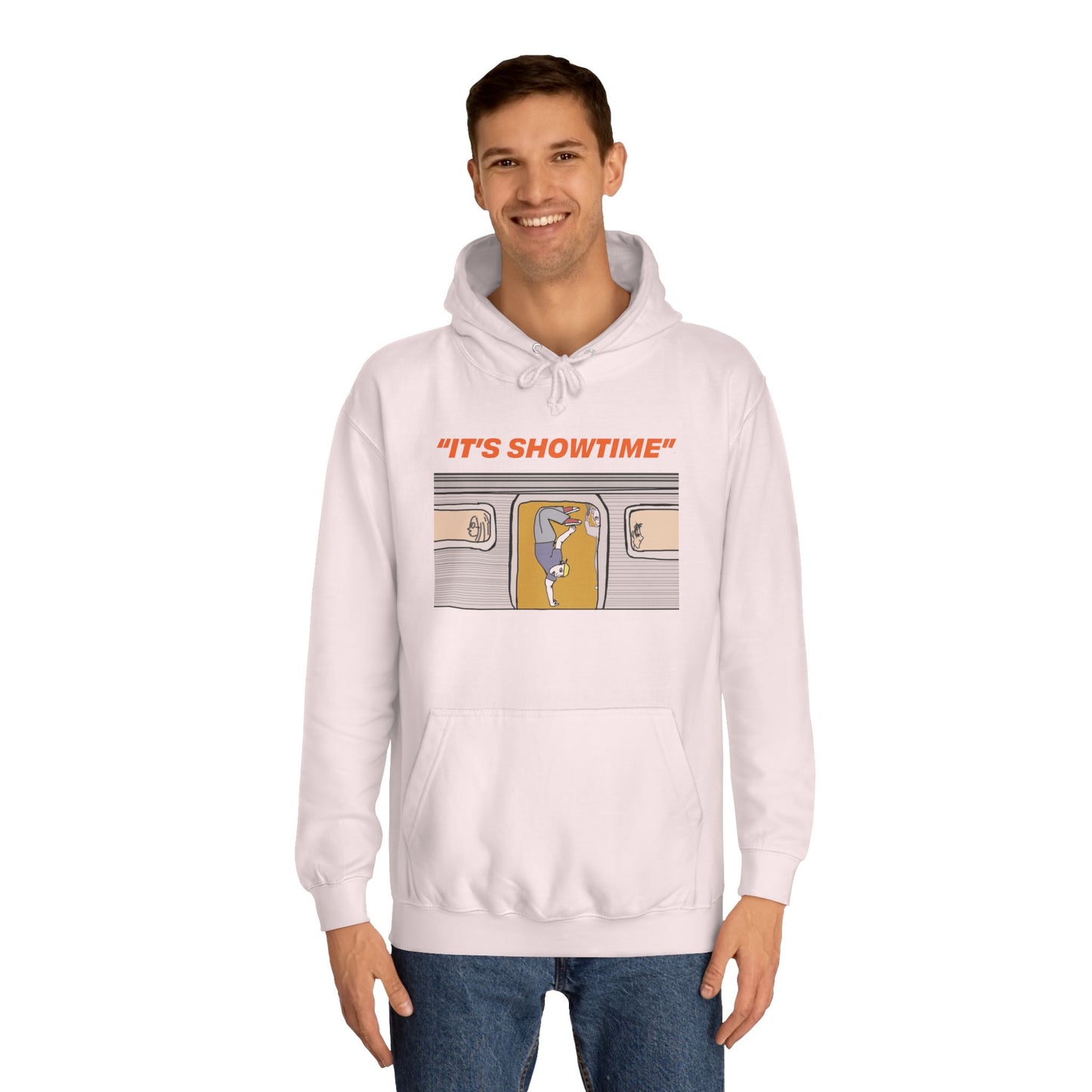 Male model wearing light pink It’s Showtime Hoodie with subway performer artwork on front.