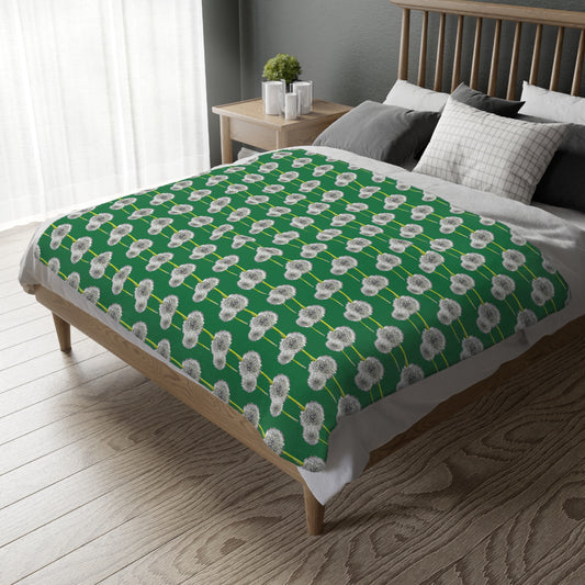 Green blanket with soft white dandelion print spread on a modern bed