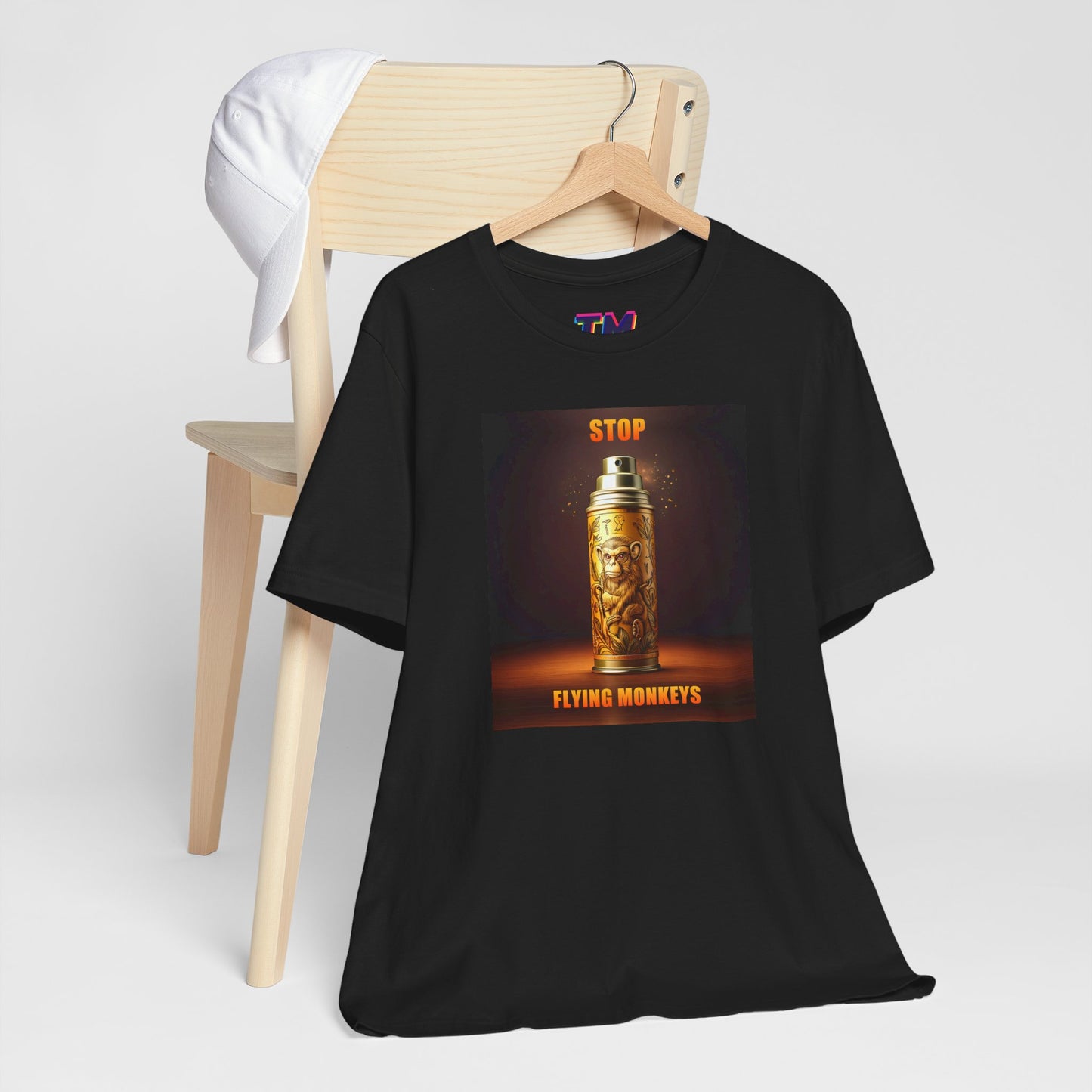 Stop Flying Monkeys T-Shirt in black draped on chair flat lay style