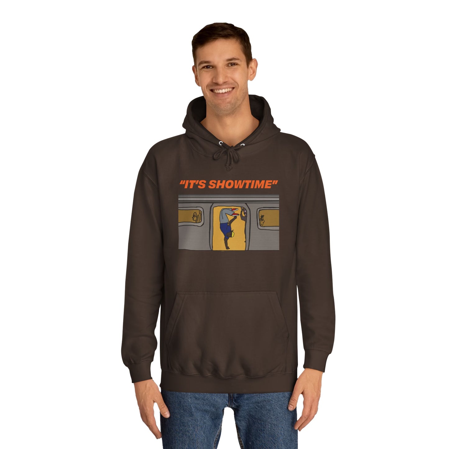 Male model wearing dark brown It’s Showtime Hoodie with subway performer artwork on front.