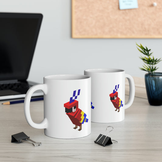 Two white ceramic coffee mugs with a pixel-art style parrot design, placed on a table with a laptop, notepad, pen, and a small plant in the background.