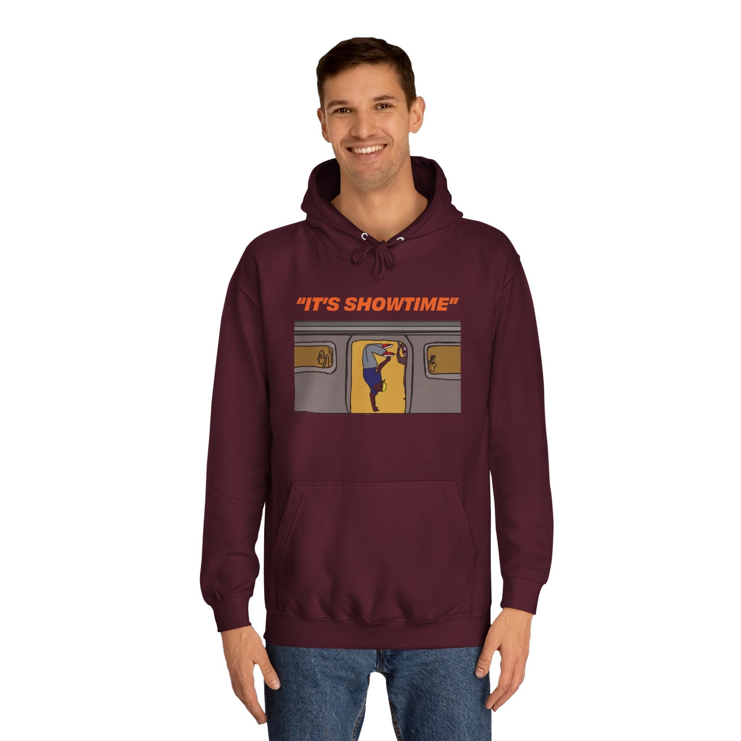 Male model wearing burgundy It’s Showtime Hoodie with subway performer artwork on front.