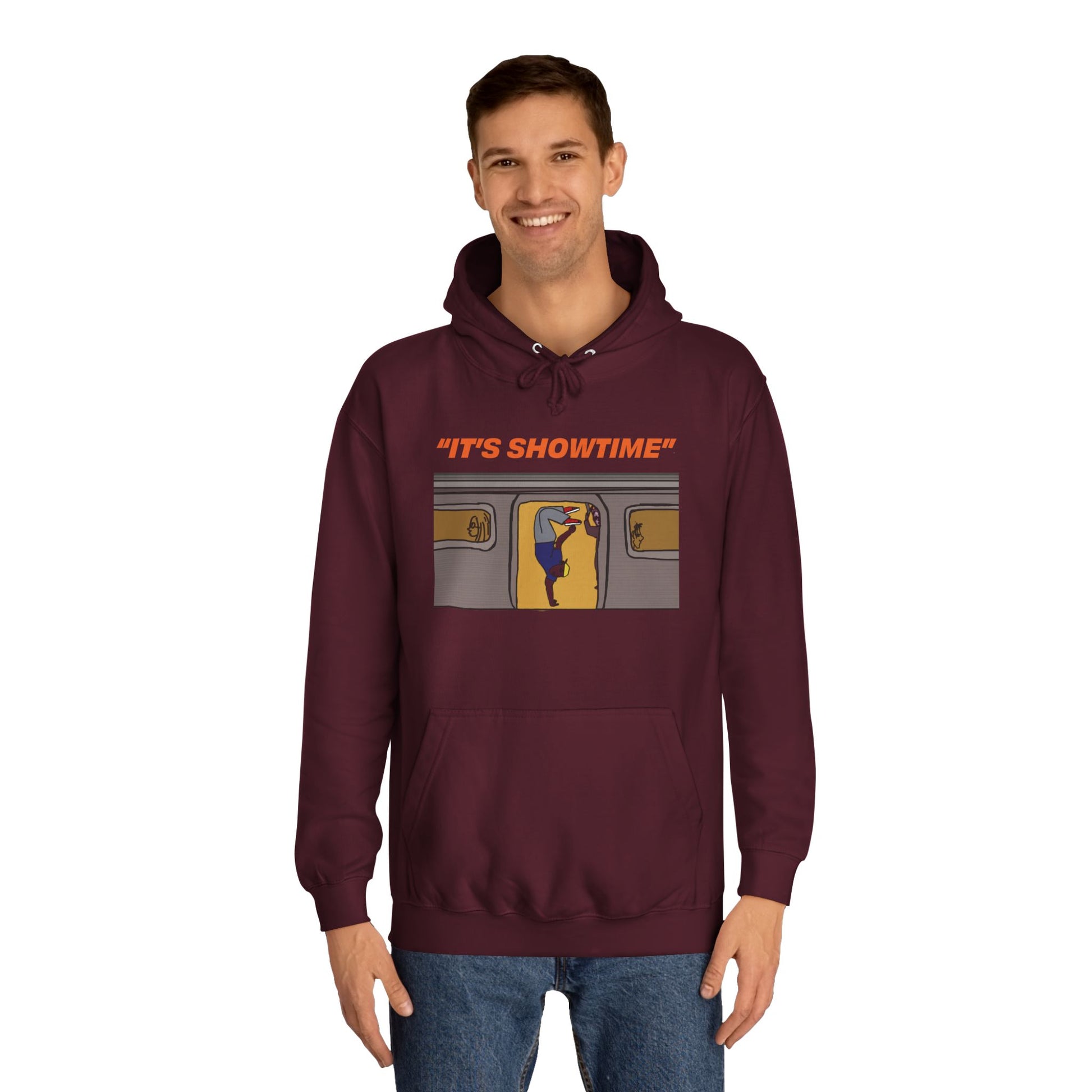 Male model wearing burgundy It’s Showtime Hoodie with subway performer artwork on front.