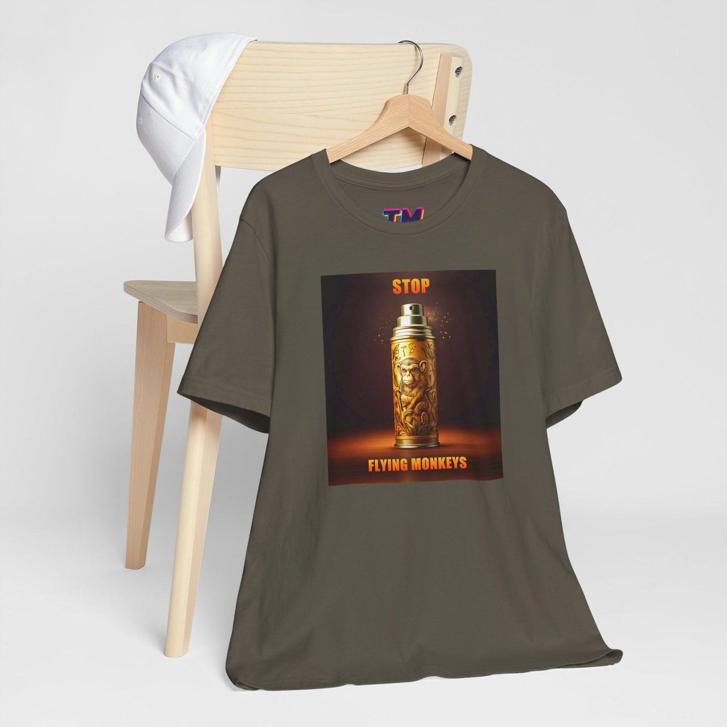 Olive Stop Flying Monkeys T-Shirt folded on chair with design visible