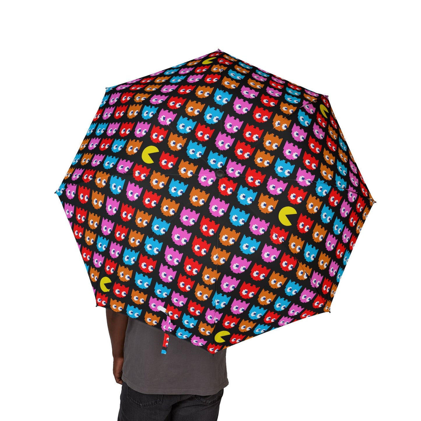 Person holding a Pac-Man themed semi-automatic umbrella featuring colorful ghosts and retro arcade patterns made of 100% polyester