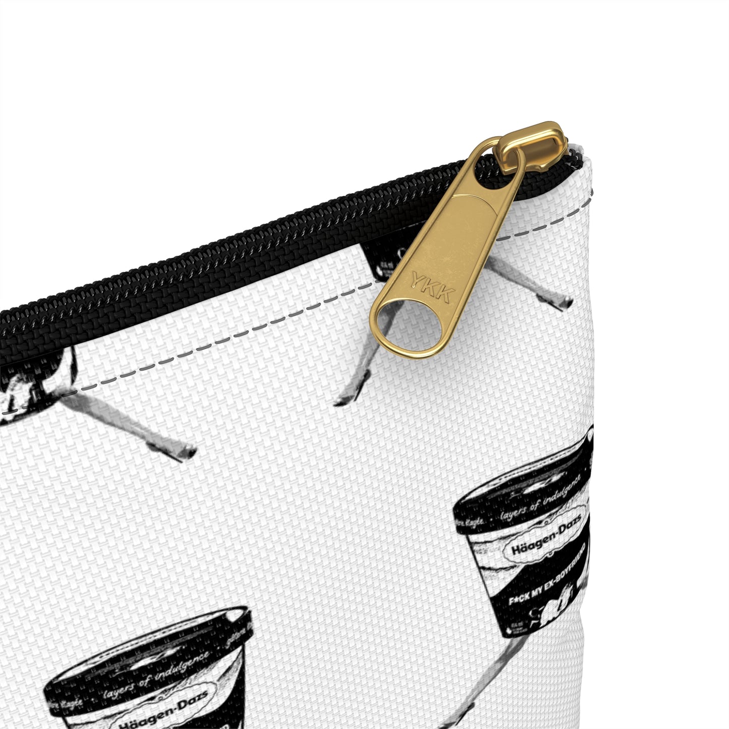 Close-up of a white pouch with black and gold zipper and branding.