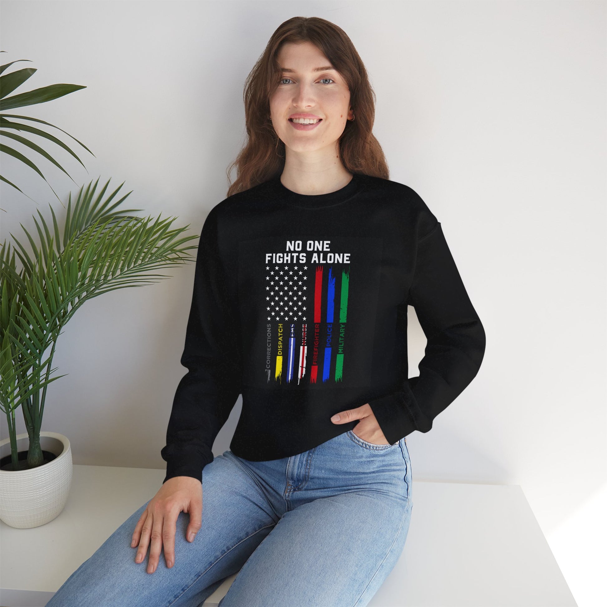 Female model wearing black Veterans Day sweatshirt with “No One Fights Alone” design