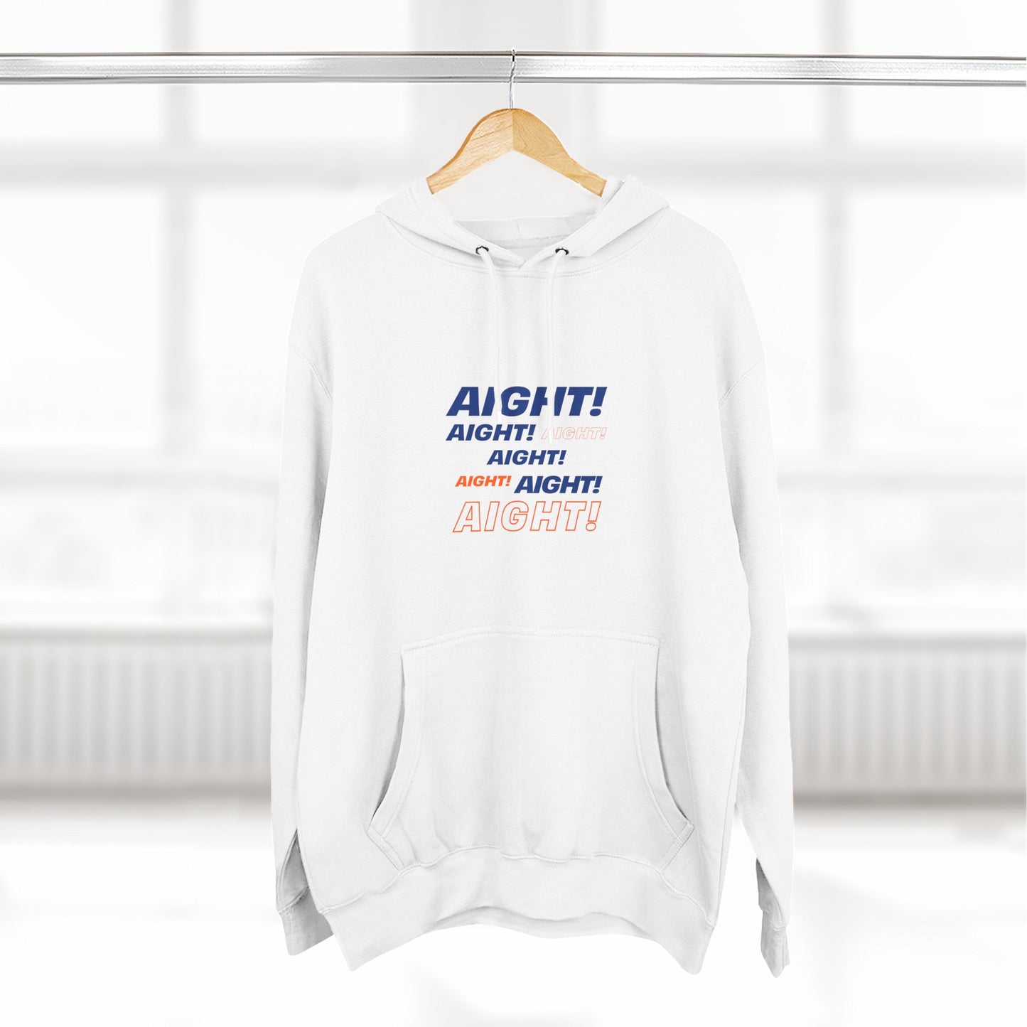 White AIGHT hoodie with blue and orange text hanging on wooden hanger in bright room
