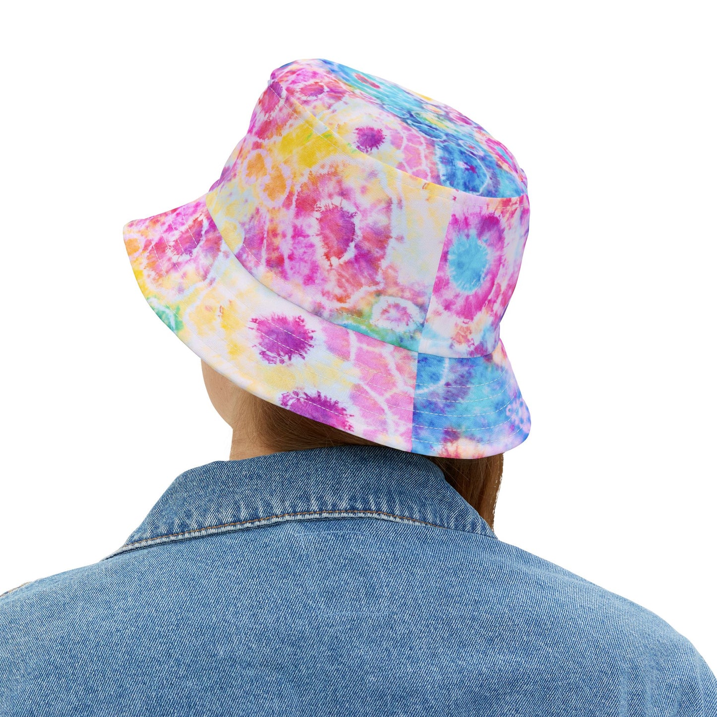 Person wearing a colorful tie-dye bucket hat on a white background