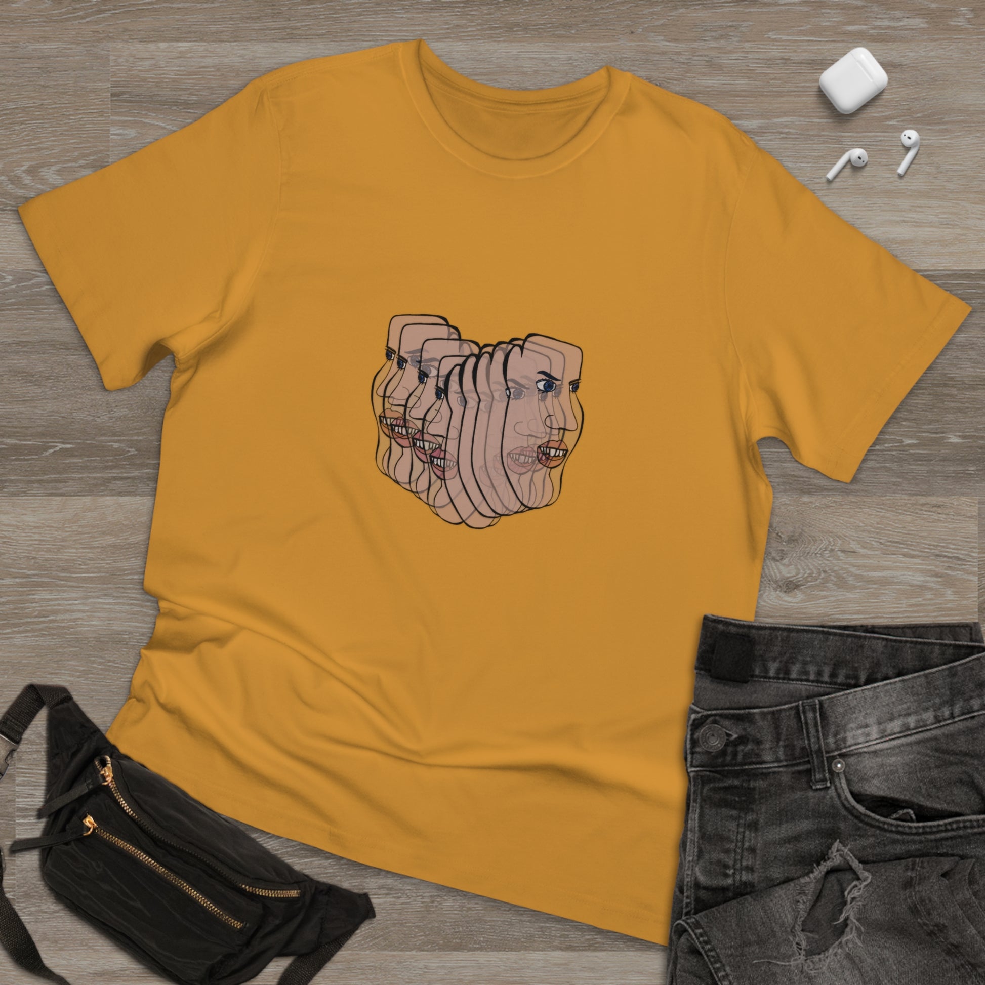 Mustard yellow Charlie t-shirt on a wooden surface with black jeans and a fanny pack on the side