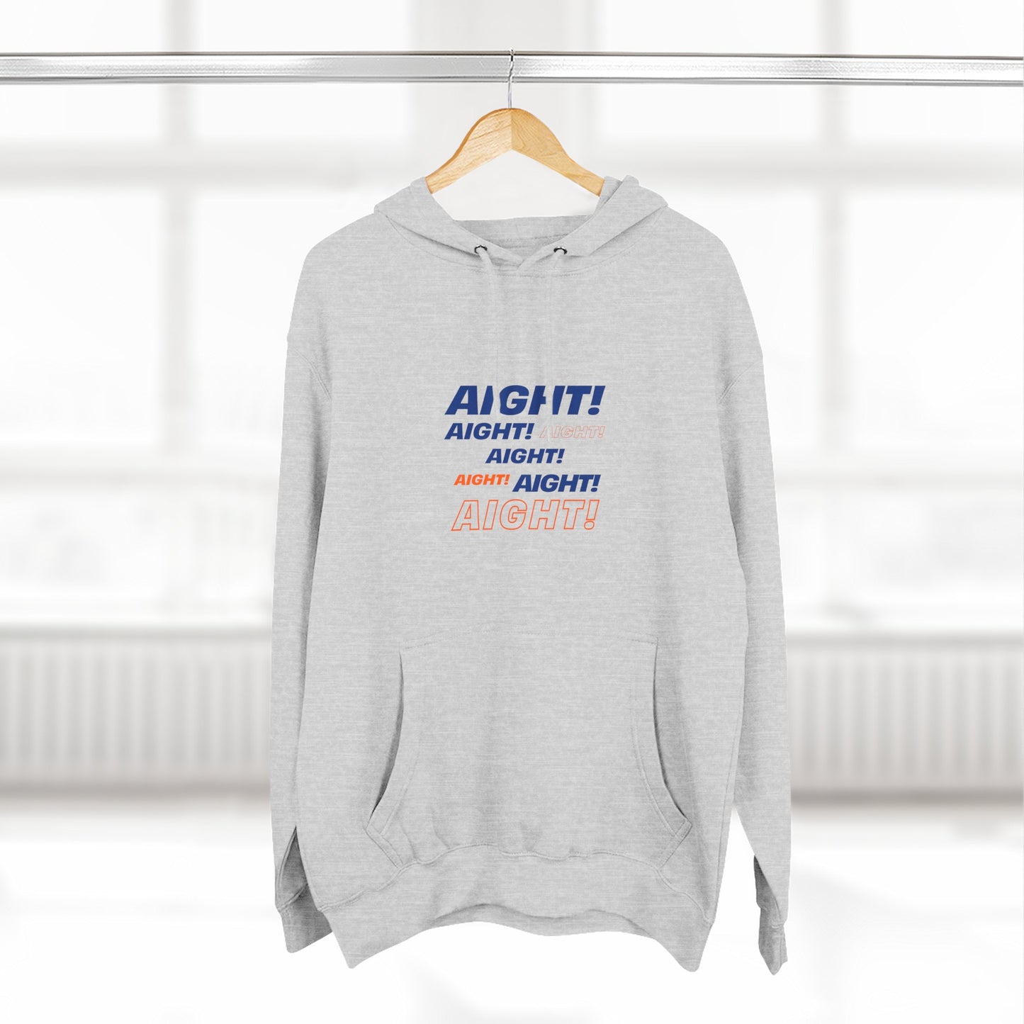 Gray AIGHT hoodie with blue and orange text hanging on wooden hanger in bright room