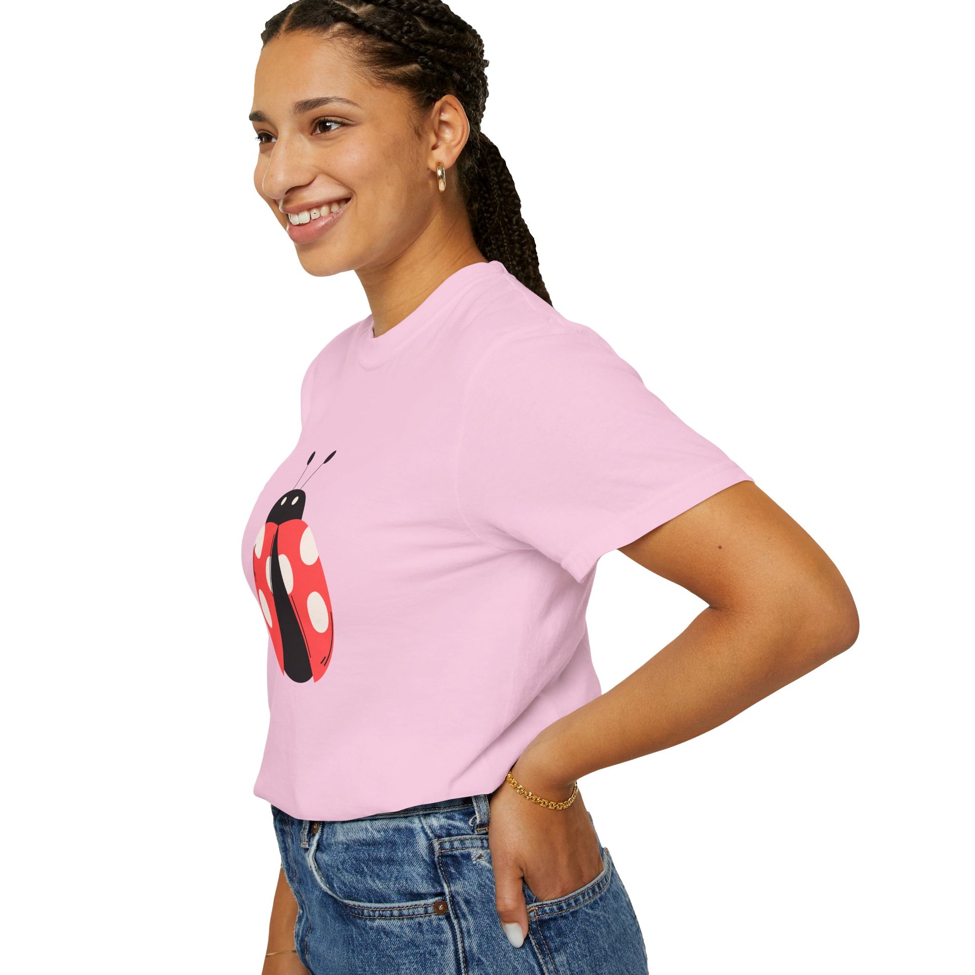 Woman in light pink Lady Bug T-Shirt with lady bug graphic, smiling side pose.