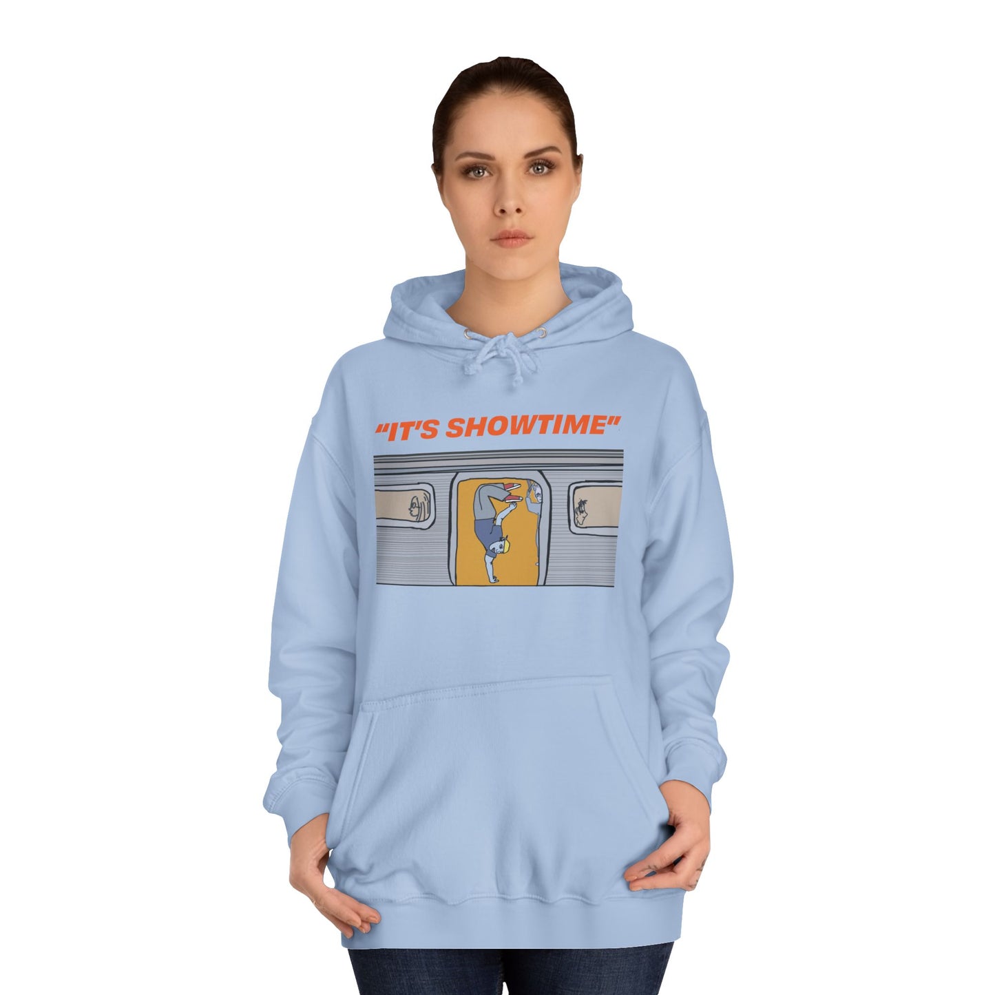 Female model wearing light blue It’s Showtime Hoodie with subway performer artwork on front.