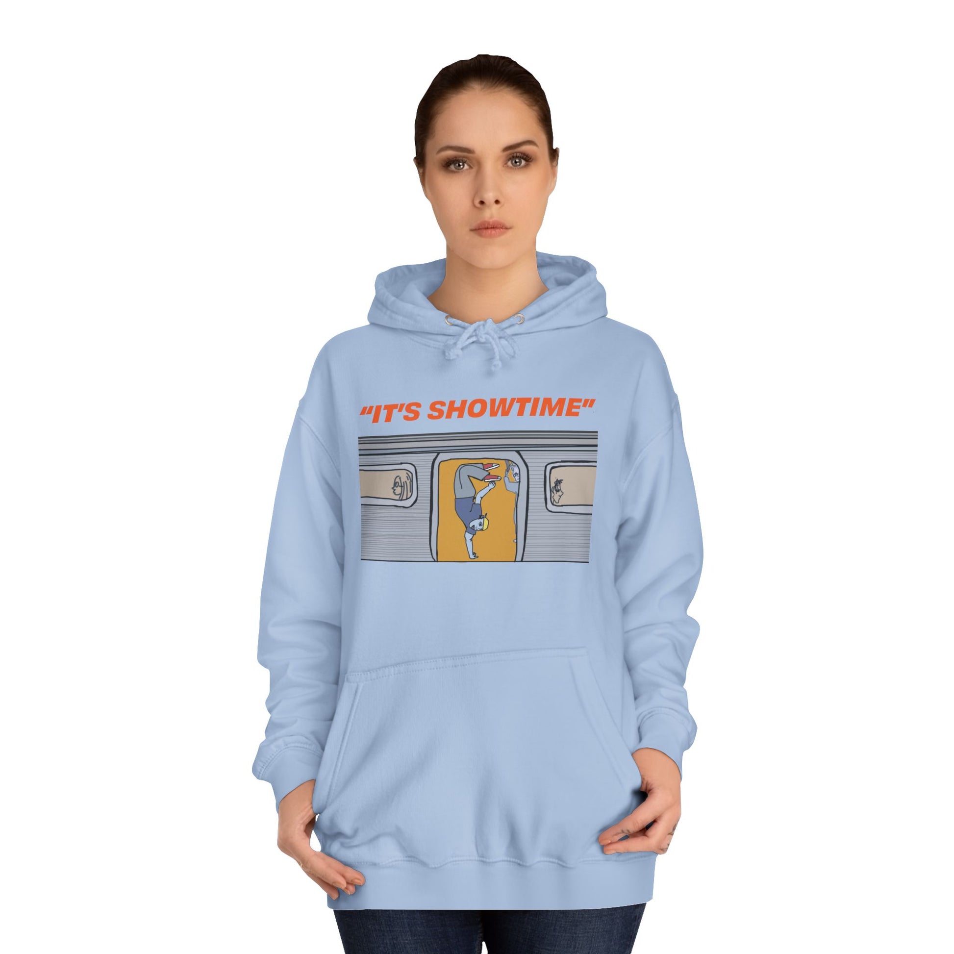 Female model wearing light blue It’s Showtime Hoodie with subway performer artwork on front.