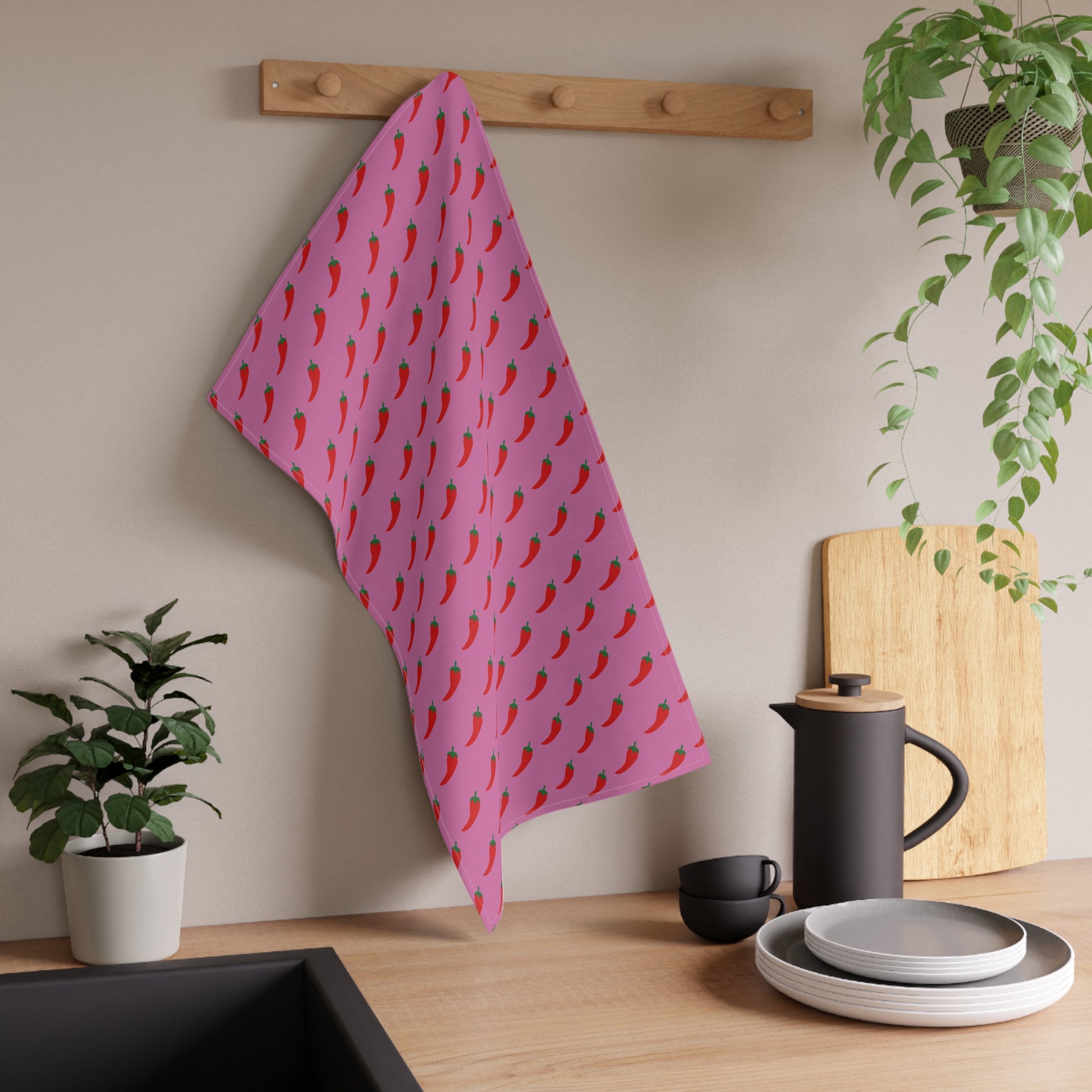 Pink Pepper Kitchen Towel styled on kitchen wall hook with plants and dishes