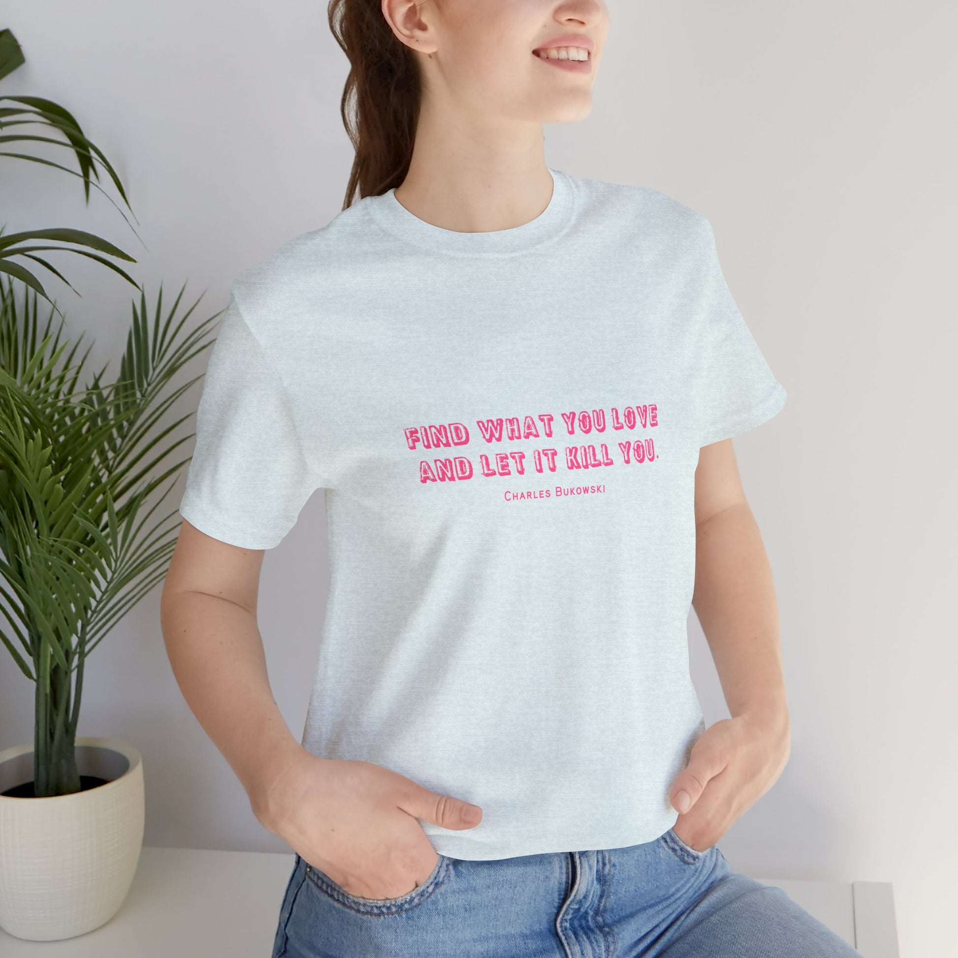 Woman wearing a light blue Bukowski quote t-shirt with tucked-in jeans.