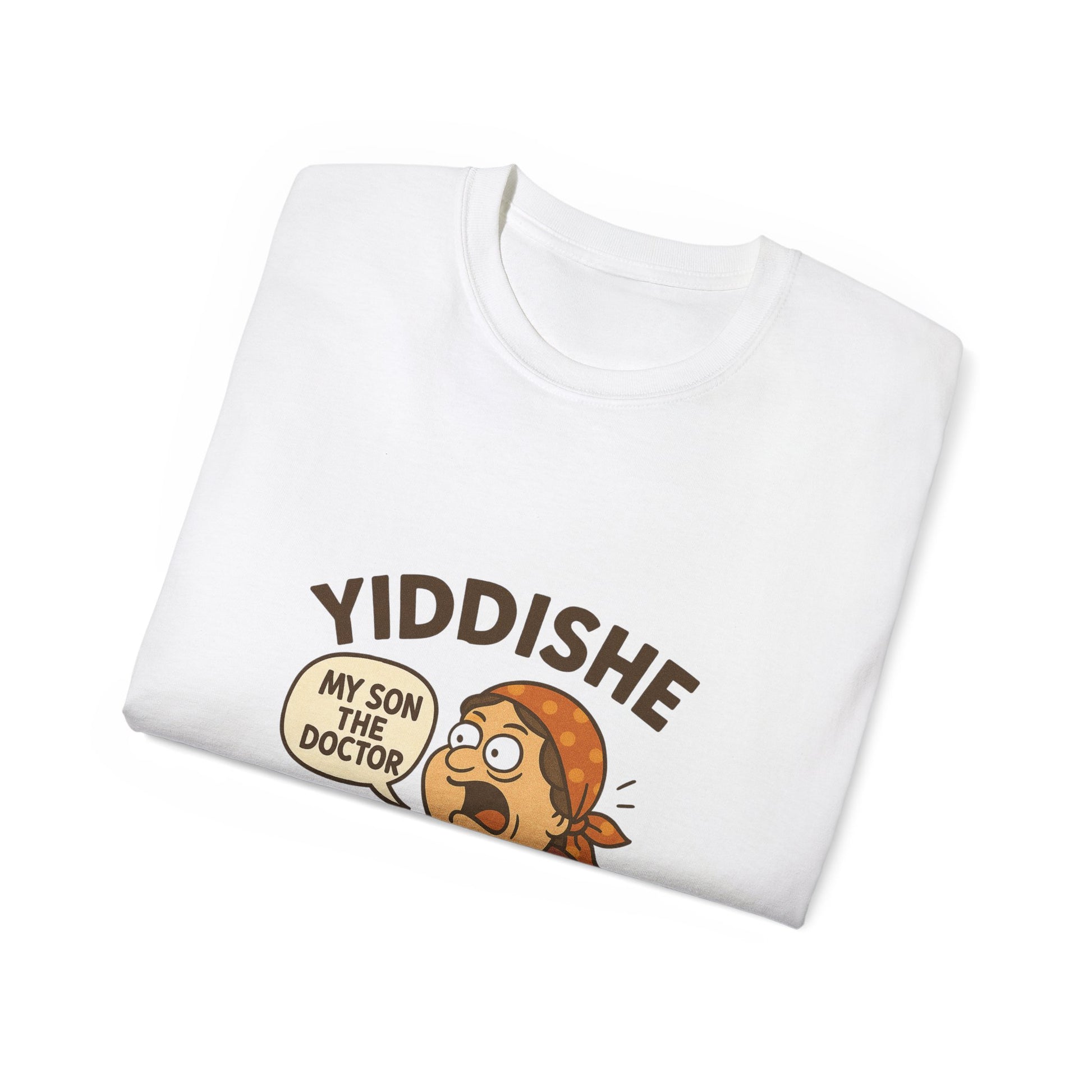 Folded white Yiddishe Momme T-shirt with cartoon of a proud mother saying “My son the doctor” in a speech bubble, celebrating classic Jewish humor.