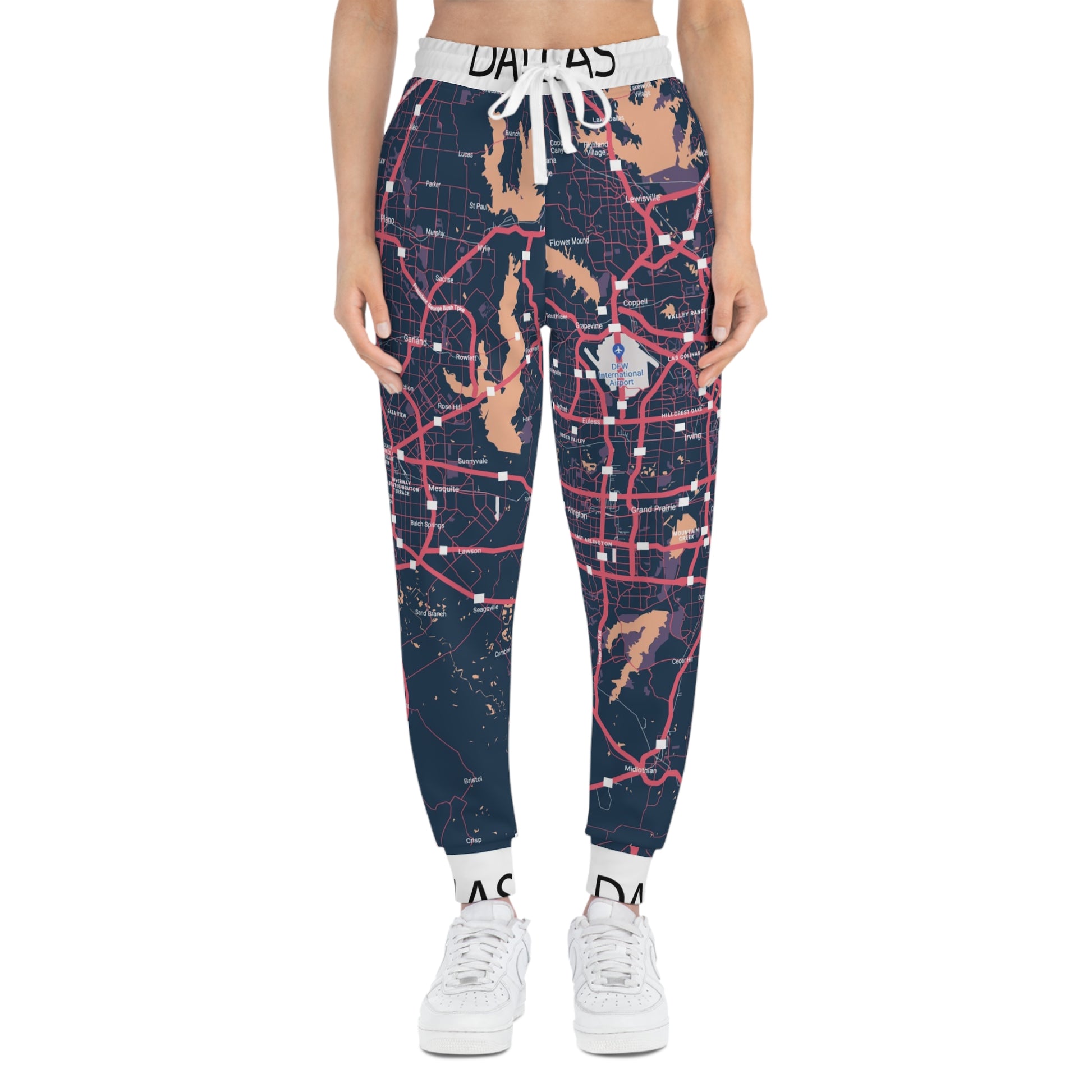 Person wearing navy blue map-patterned jogger pants with white sneakers on a white background