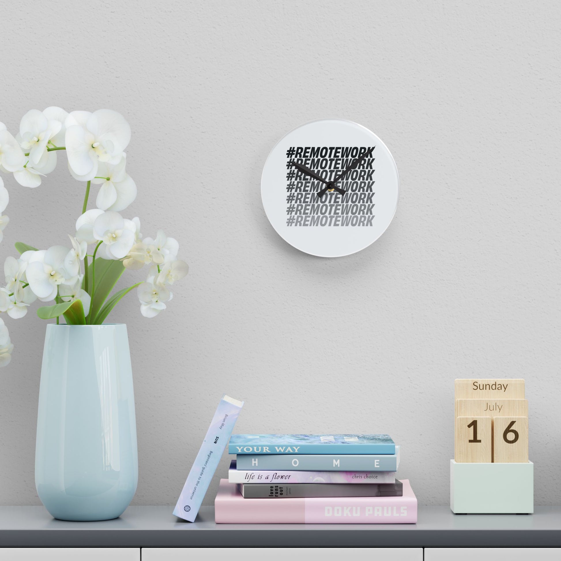 Decorative clock with 'REMOTEWORK' text, vase with flowers, books, and calendar on a shelf.