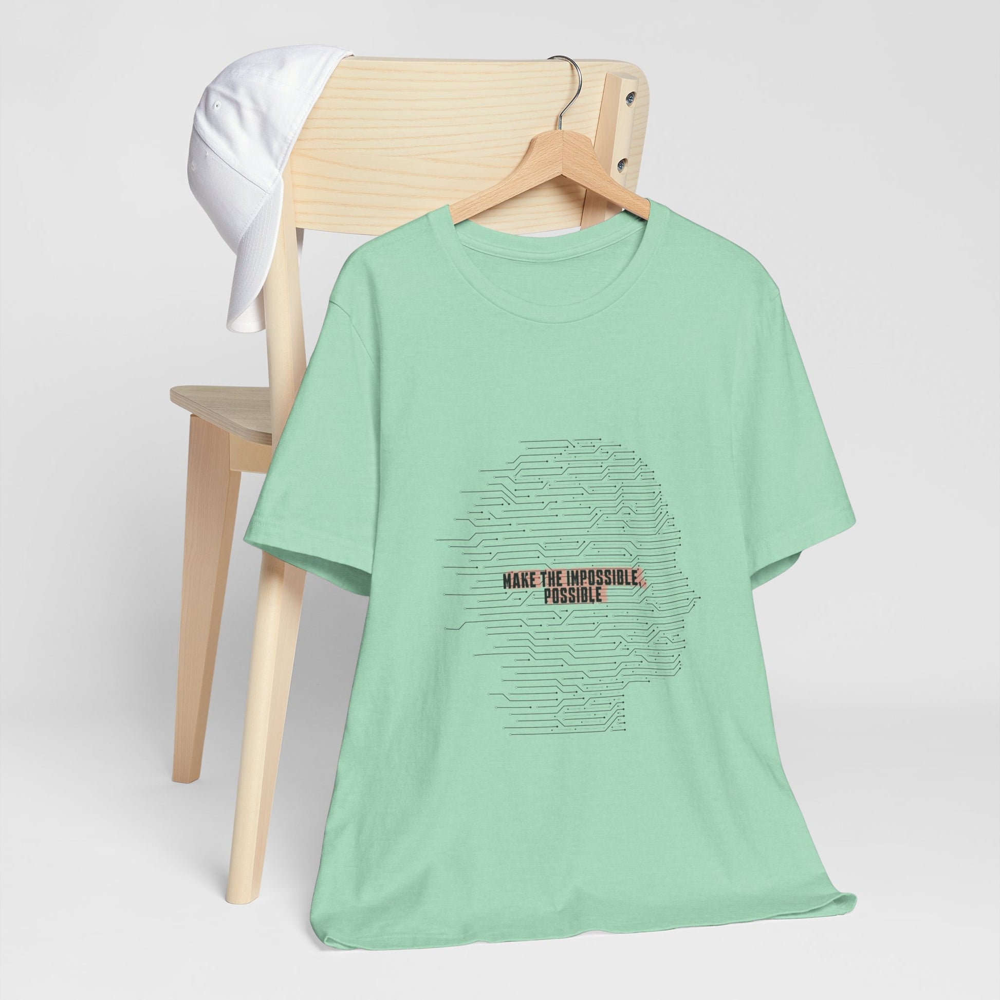 Green Make It Possible T-Shirt on chair with inspirational message.