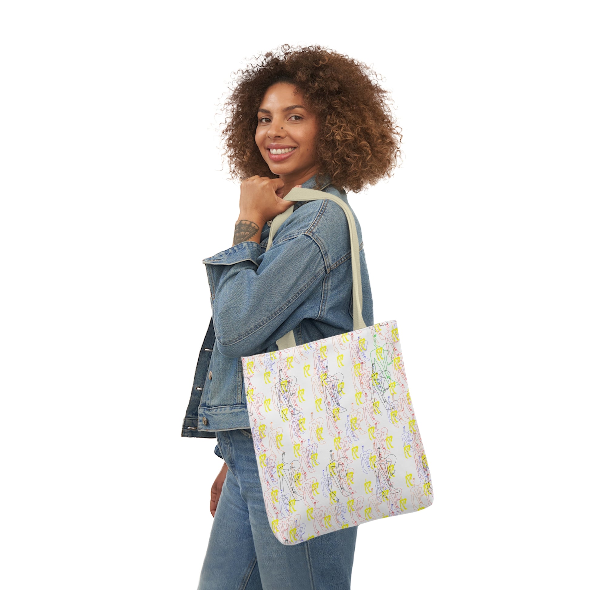 Woman carrying a white tote bag featuring a colorful repeating pattern of abstract line art figures in pastel shades