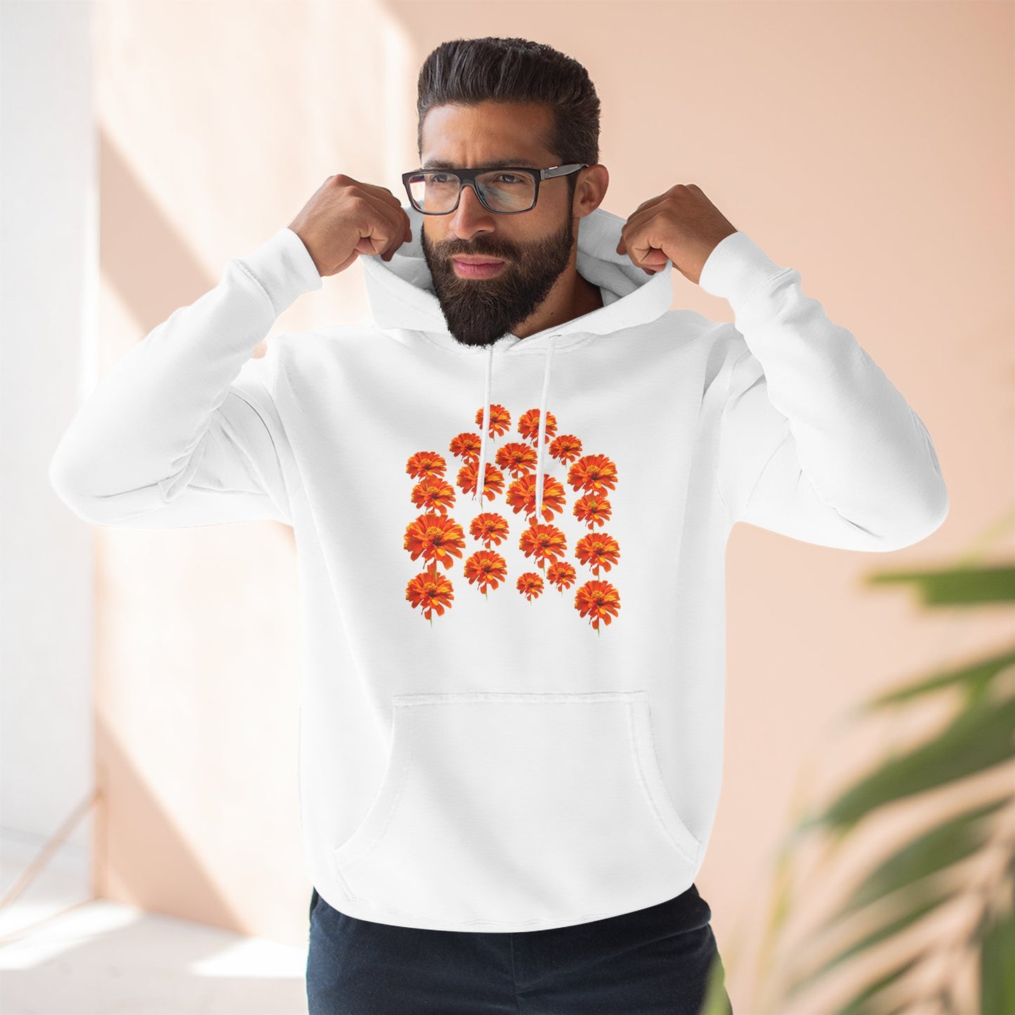 Man wearing white Zinnia Hoodie adjusting hood indoors