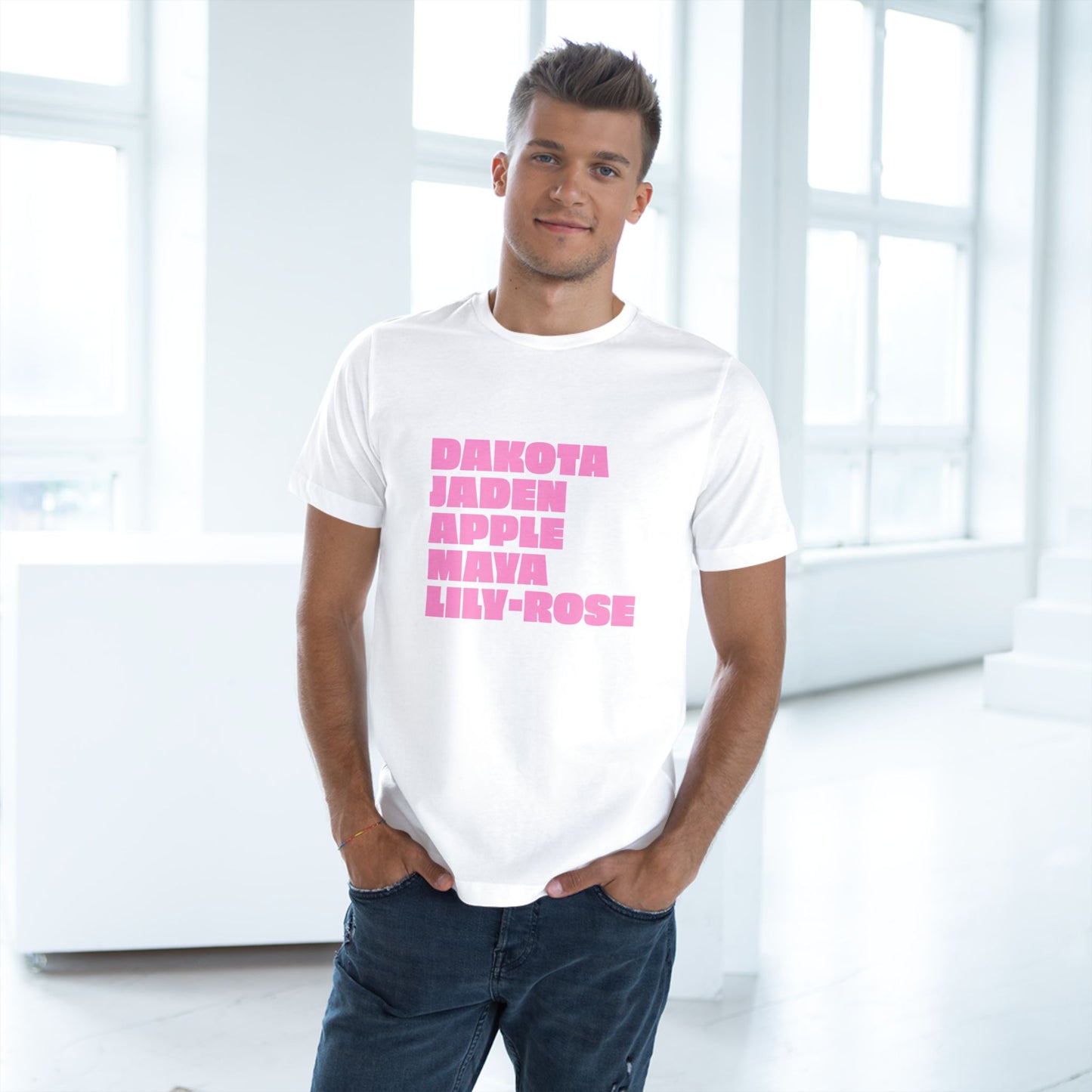 Man wearing a white t-shirt with pink text in a bright room