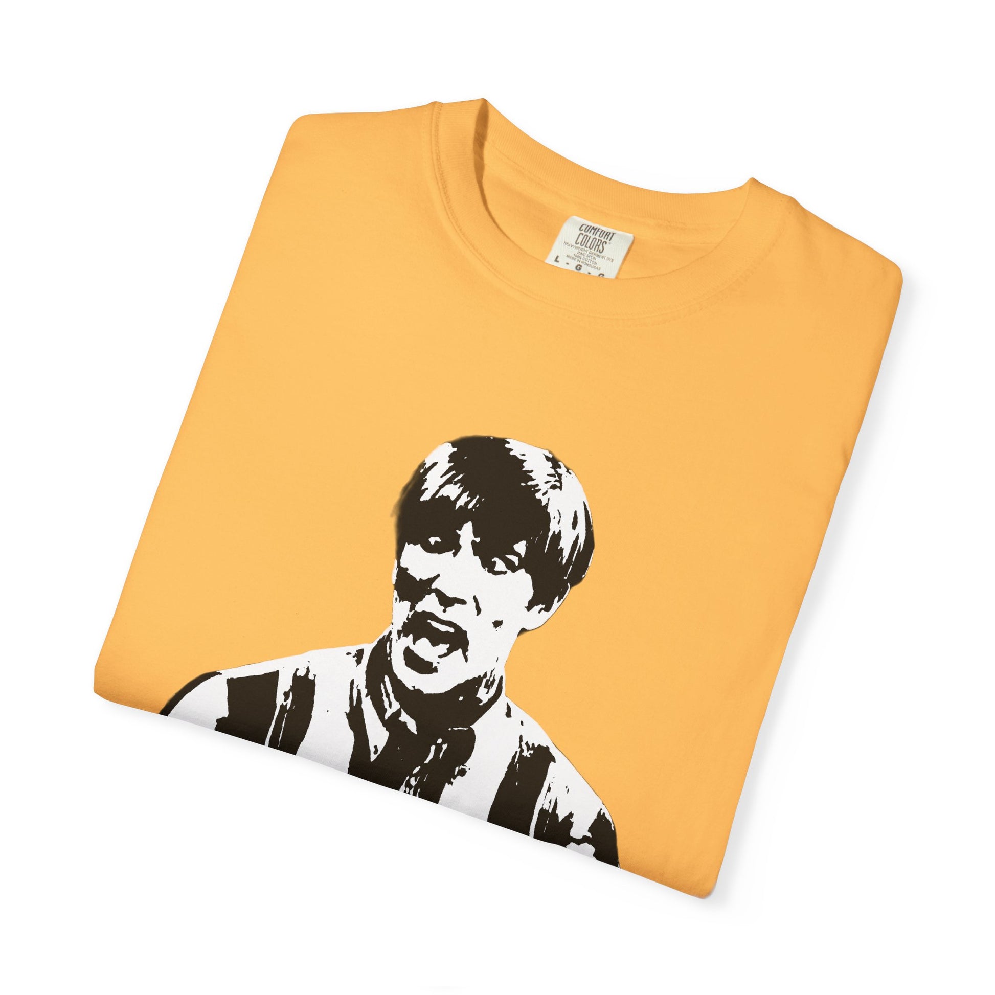 Golden yellow Stuart T-shirt folded flat with bold black-and-white graphic of Michael McDonald’s character.